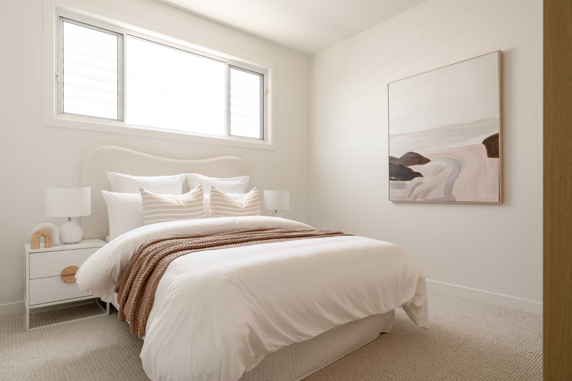 A contemporary bedroom with a neutral color palette.