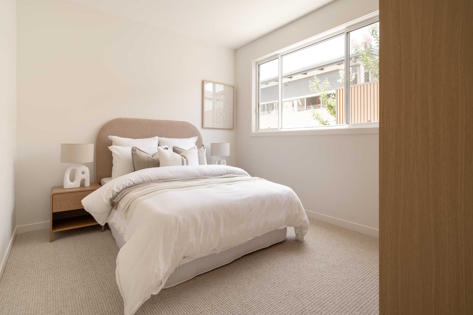 A contemporary bedroom with a neutral color palette.