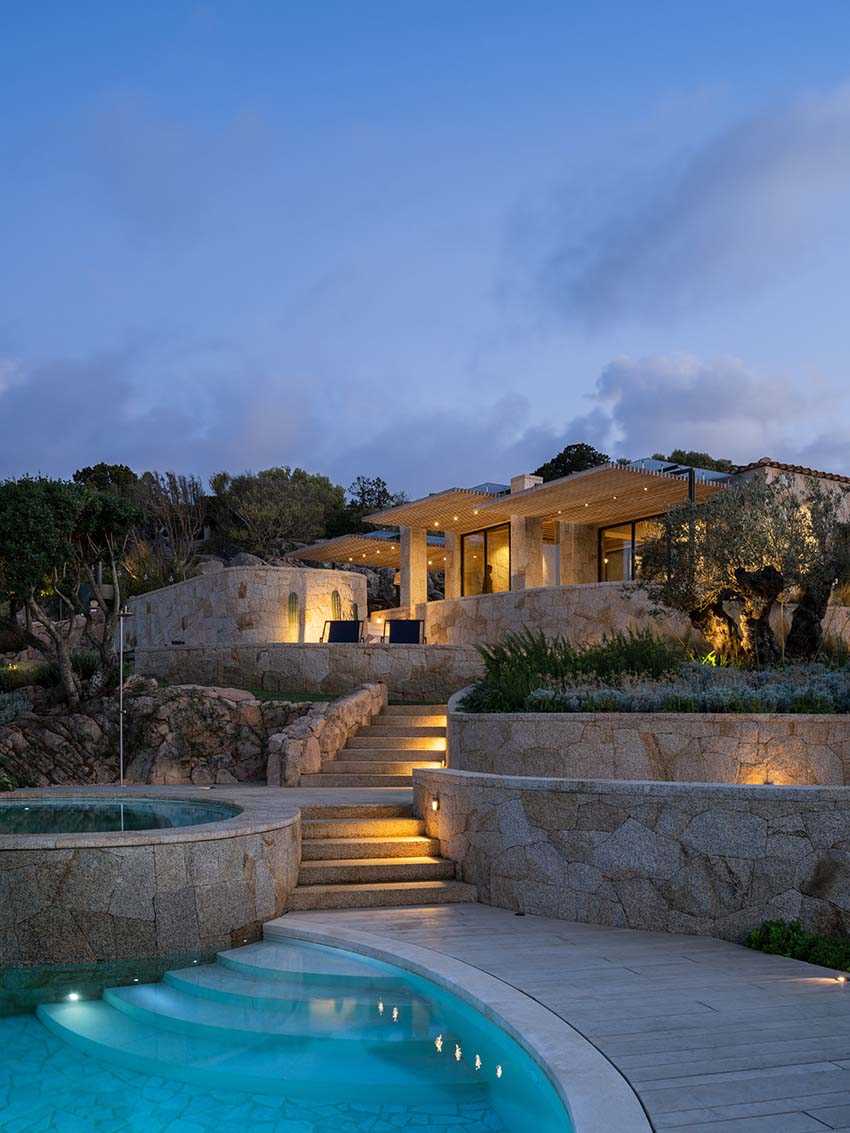 Here's a look at the home at nighttime with exterior lights highlighting the stone and design of the house.