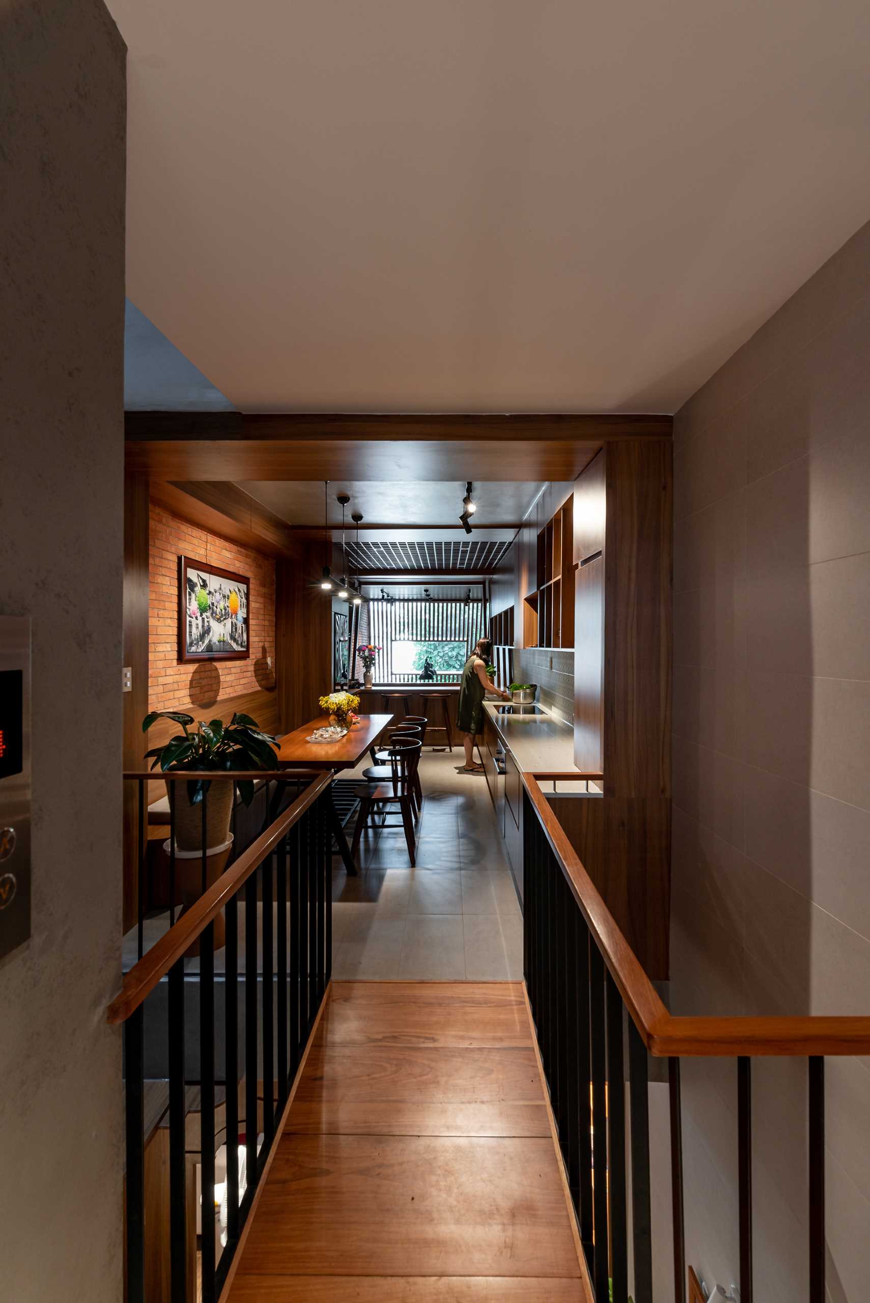 The mezzanine of this tall and skinny house, is home to the dining area and kitchen, has a skylight that can look down into the garage area and entrance hall so you can cook and look after the house at the same time.