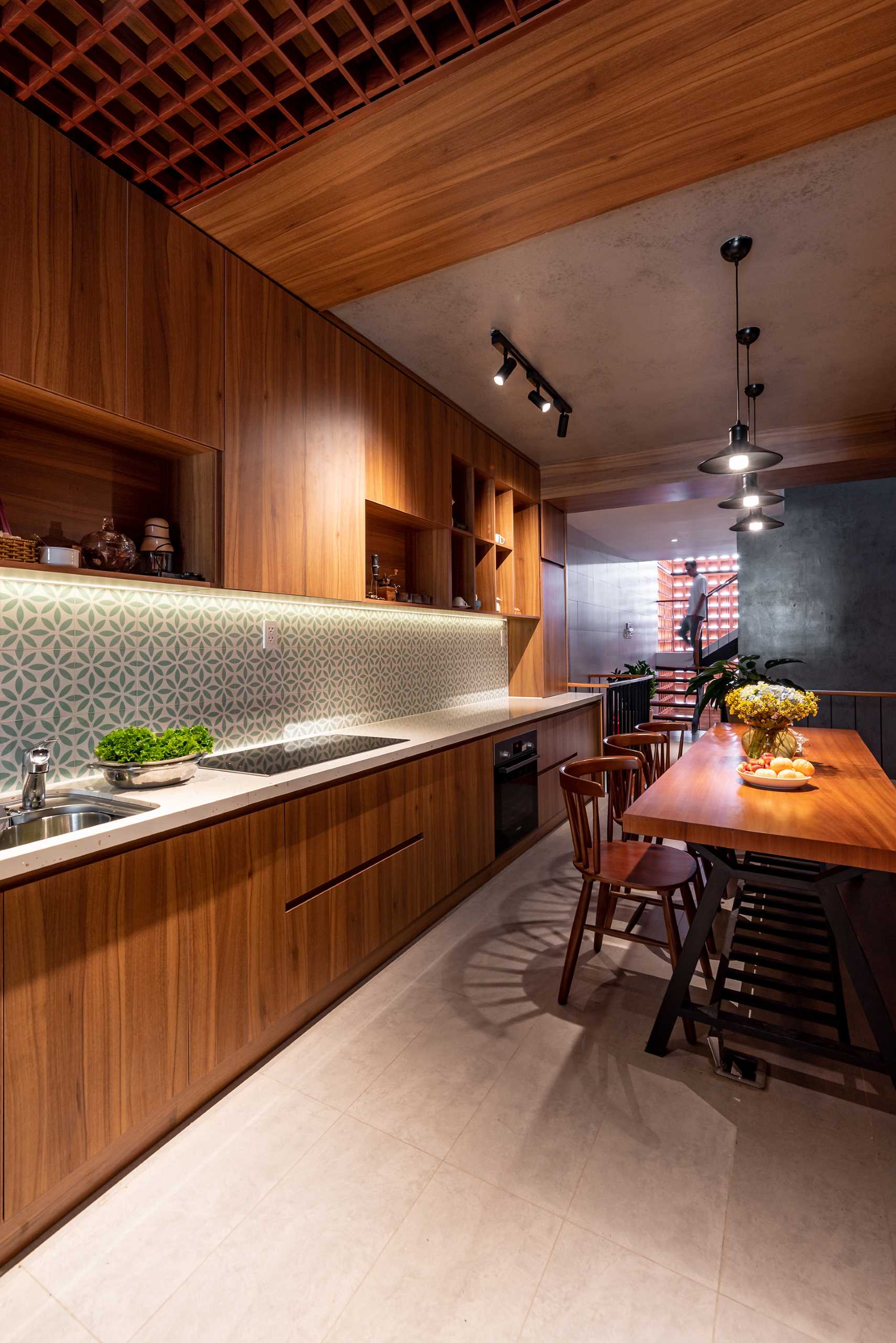 The mezzanine of this tall and skinny house, is home to the dining area and kitchen, has a skylight that can look down into the garage area and entrance hall so you can cook and look after the house at the same time.