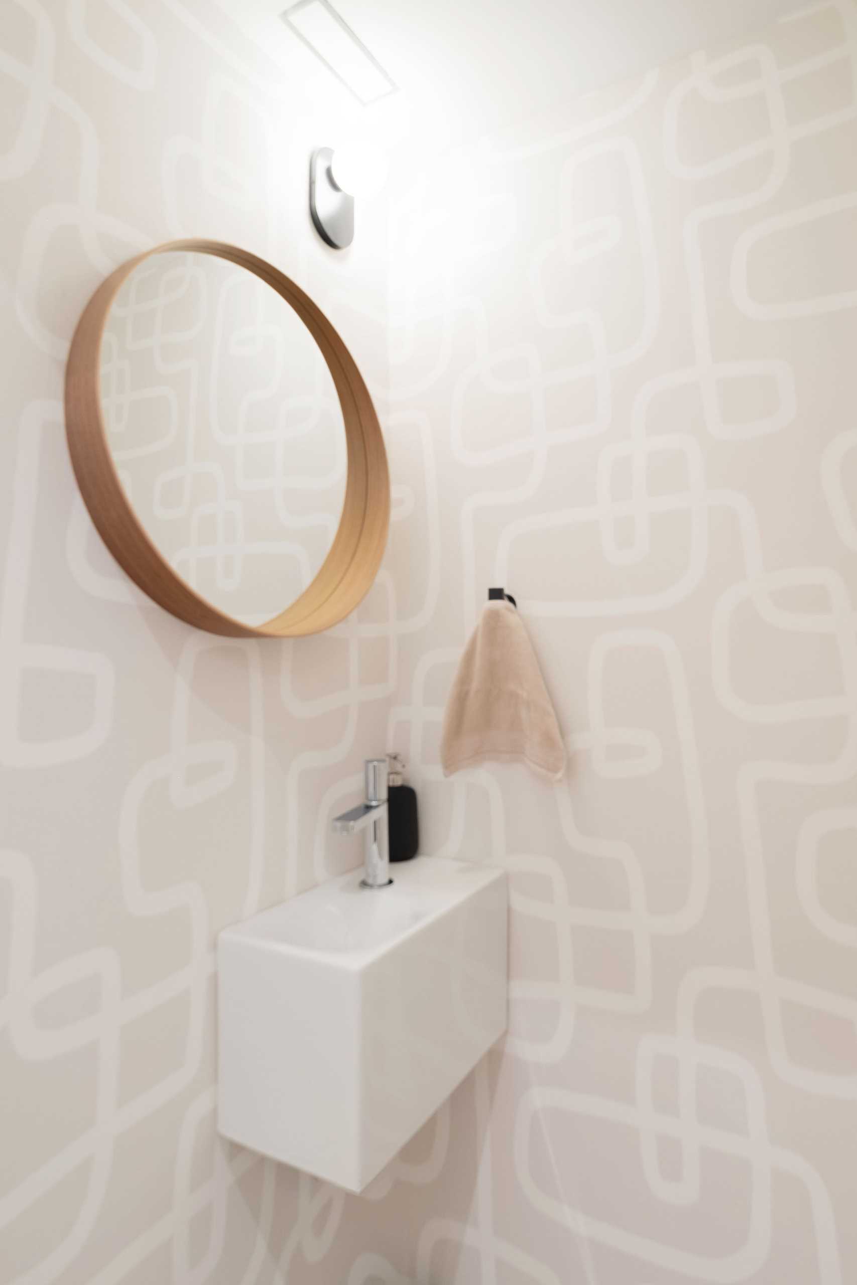A neutral bathroom with a patterned wallpaper.