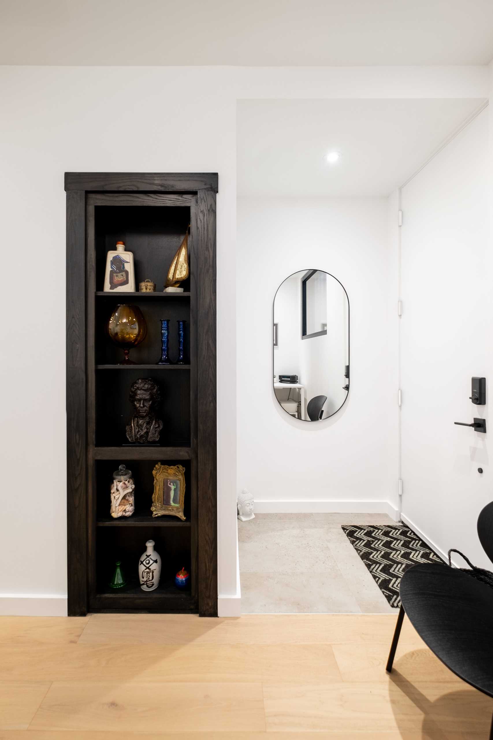 A laneway house opens up to a den with a desk, a sitting area, and a built-in shelving niche.