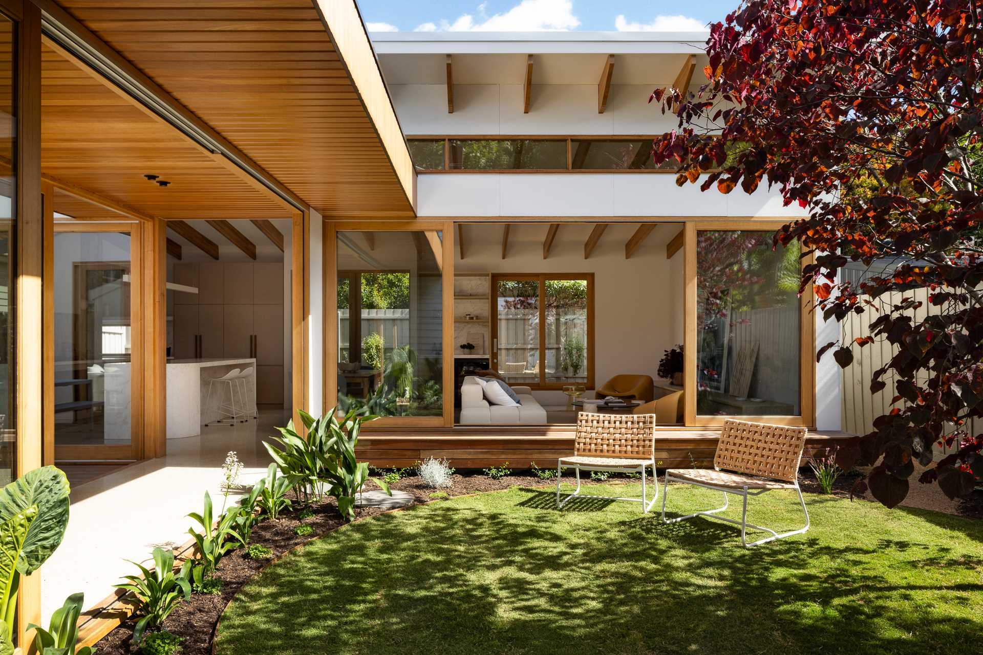 An Australian home received a modern addition with sliding glass doors and windows, and clerestory windows.