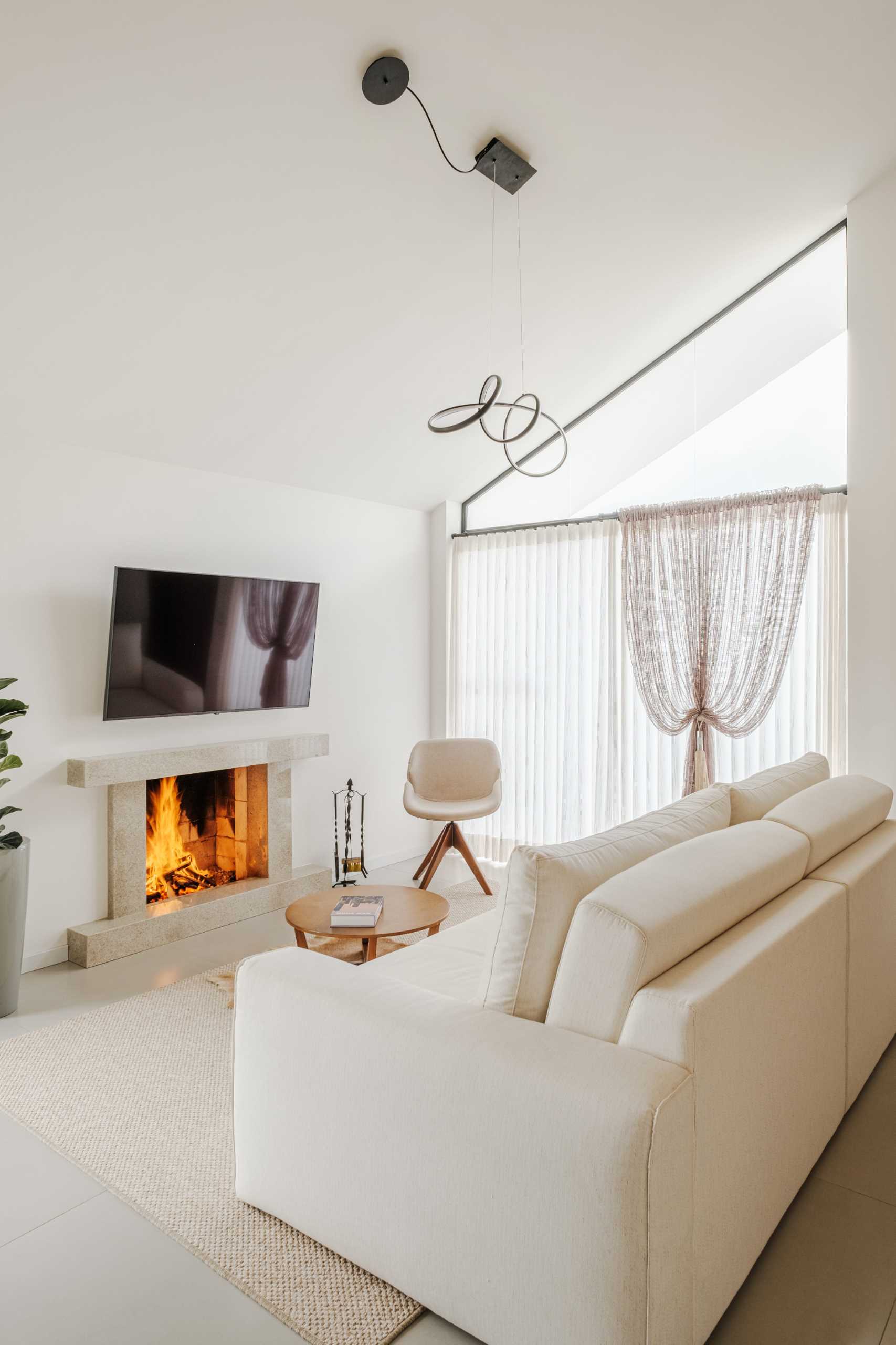 A modern living room with a wood burning fireplace.