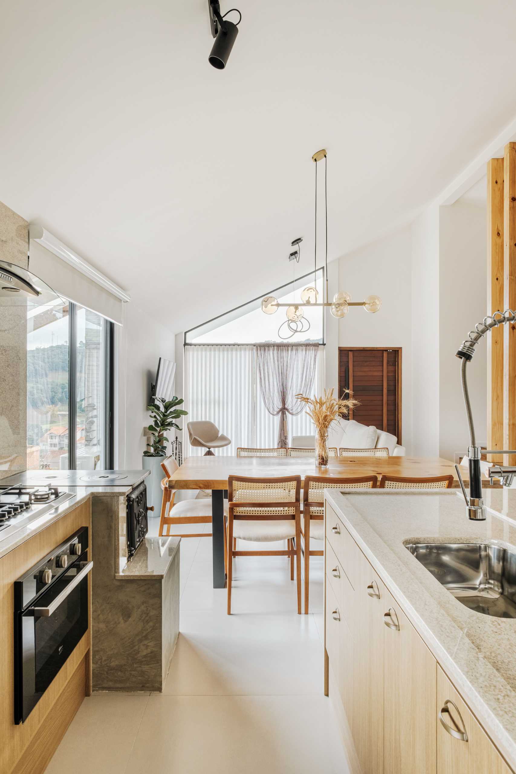 The palette of materials chosen in this modern open-plan interior, unites wood, linen, and burnt cement, which are all enhanced by the white walls and ceiling.