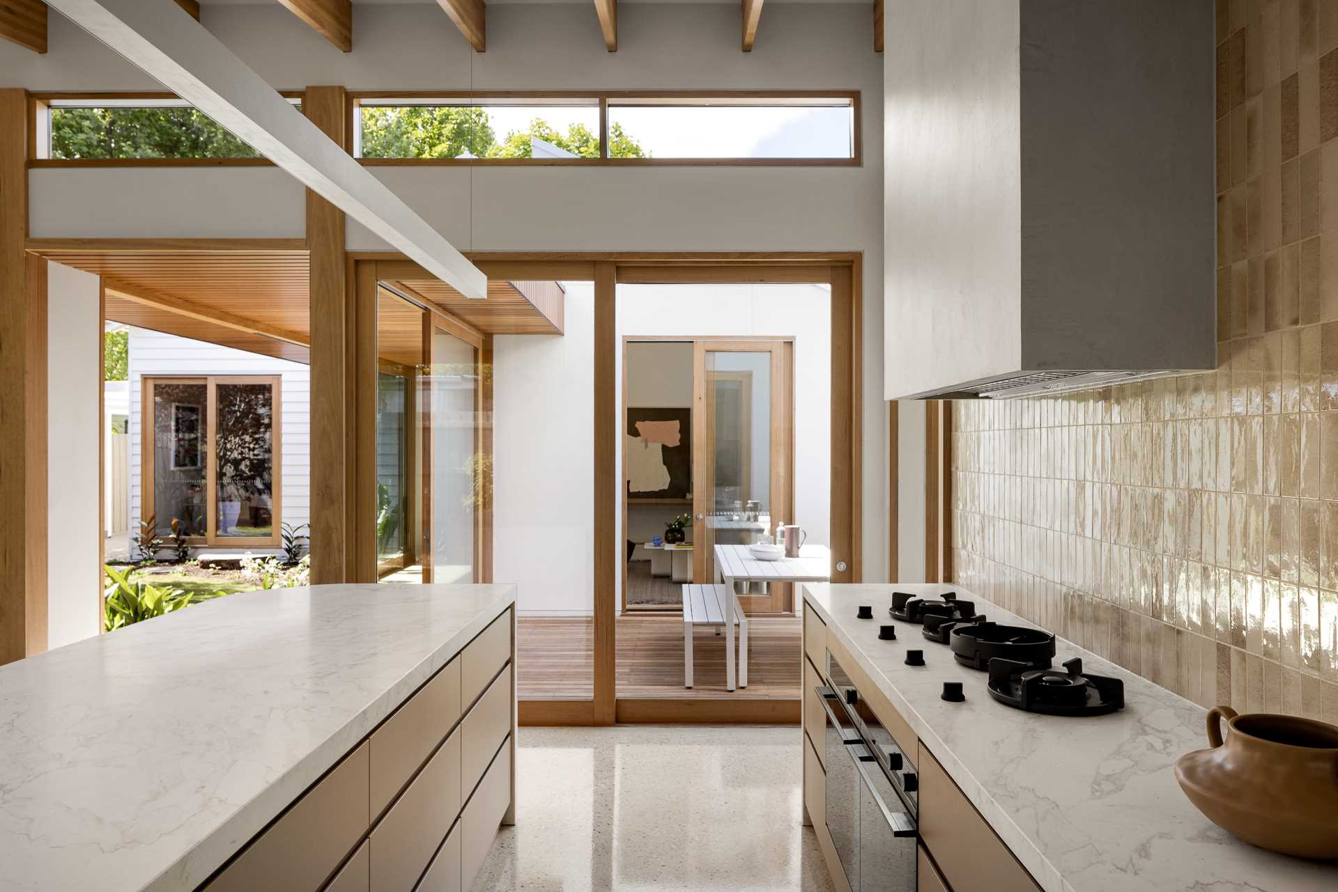 This kitchen has a sliding gl، door that connects to the outdoor dining area.