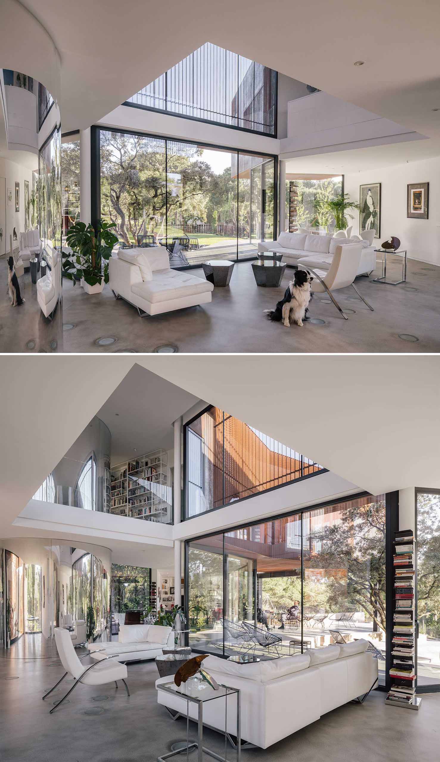 The living room is flooded with light from the double-height space, and the large windows provide uninterrupted views of the landscape.