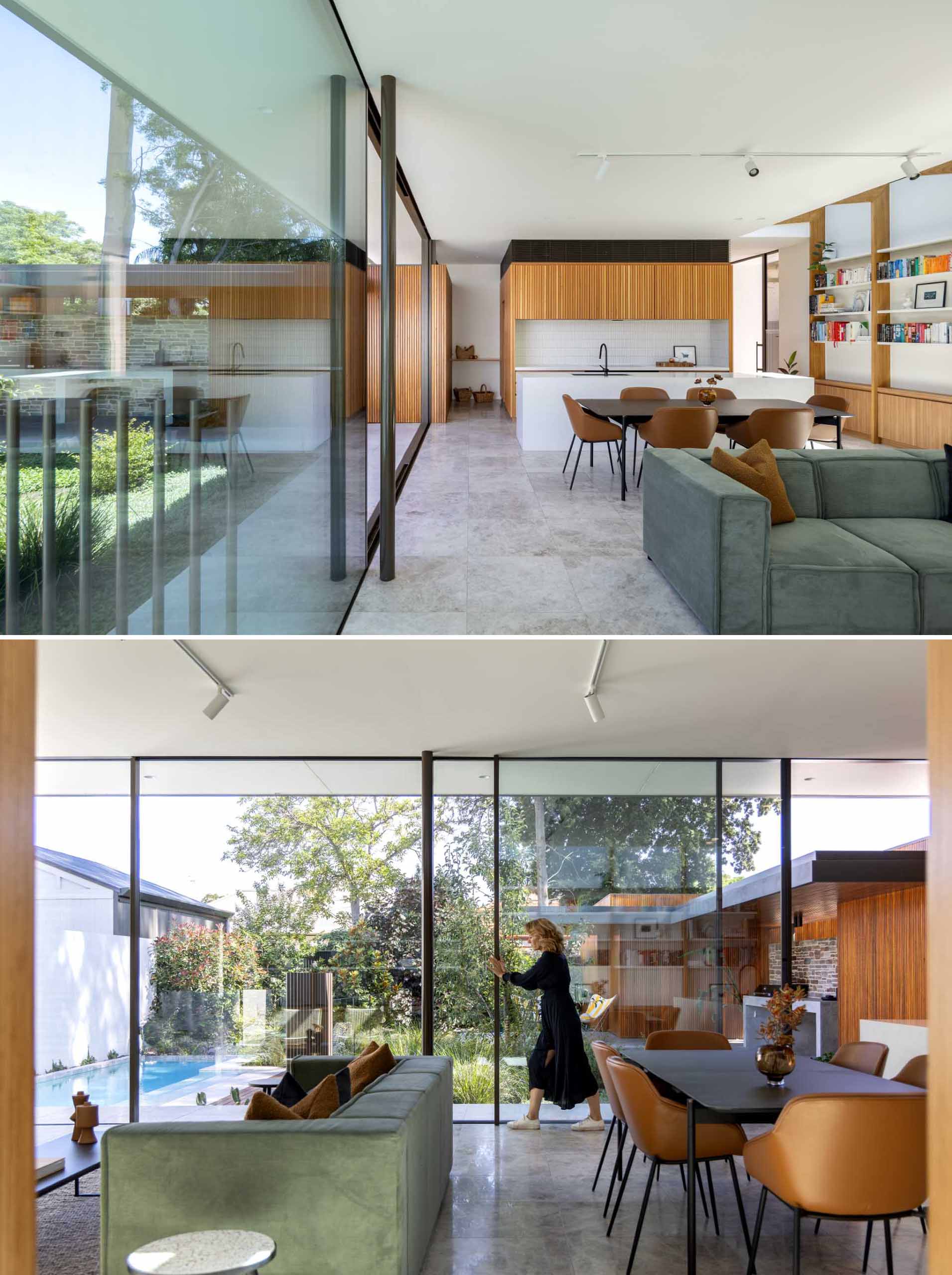 Обеденная зона открытой планировки отделяет кухню от гостиной, а раздвижные стеклянные двери высотой 9 футов (3 м) соединяют внутреннее и внешнее пространство.