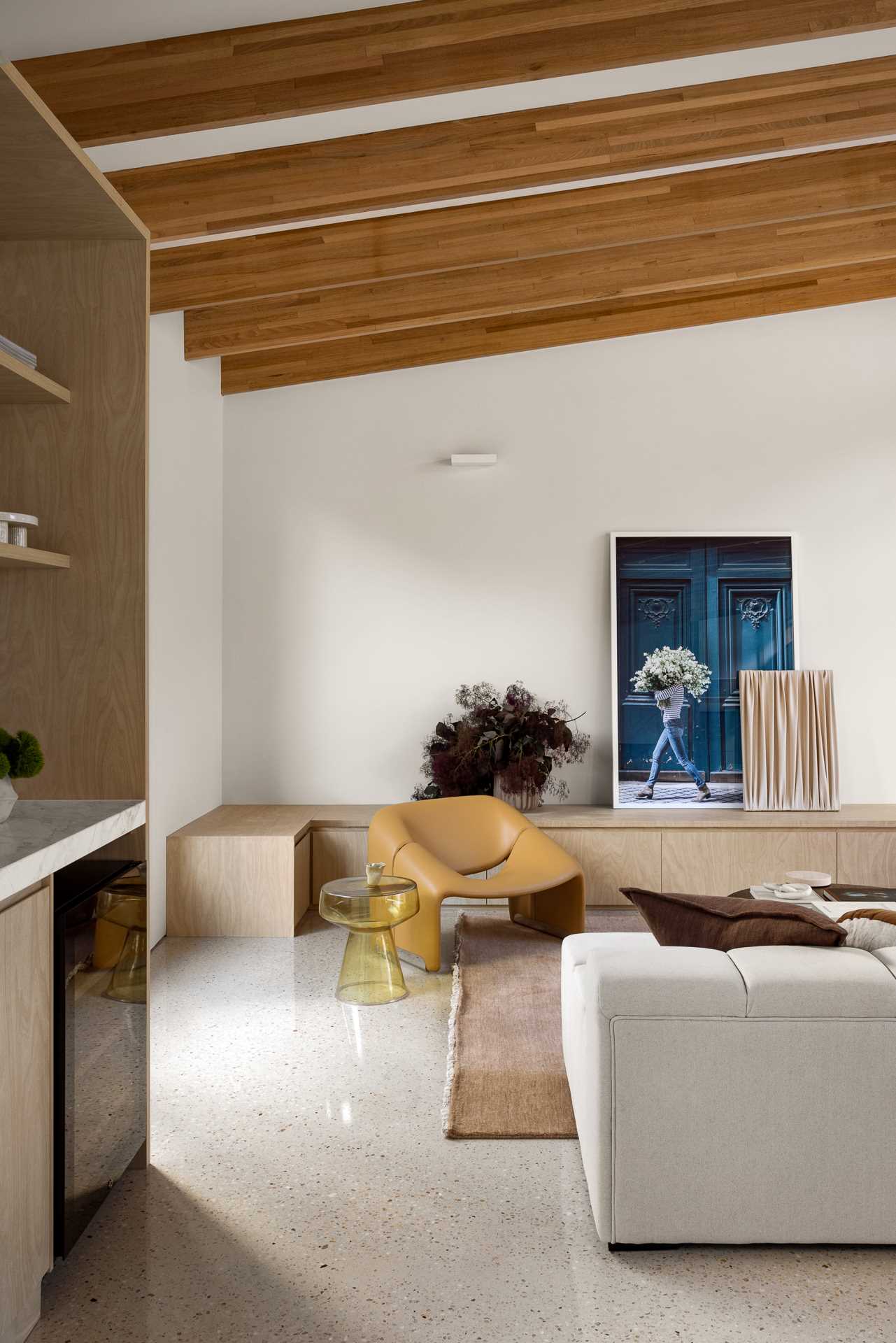 The new extension includes a large open-plan room with a living room at one end. The cathedral ceiling and high-level glazing lifts your eyes over the original dwelling, while the exposed timber beams add to the sense of warmth and detail.