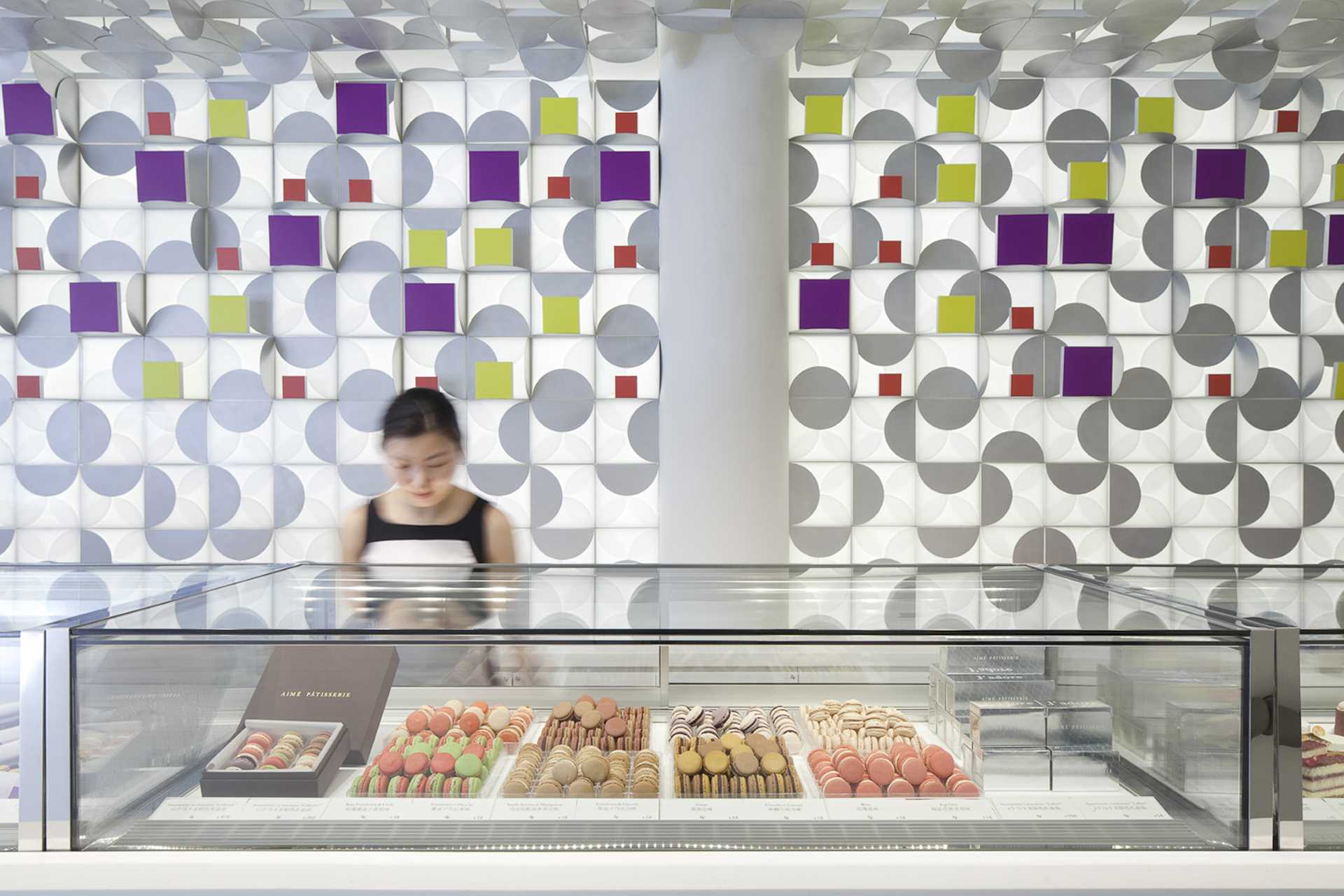 A modern patisserie whose design is inspired by the act of opening one of the gift boxes that holds their colorful macarons.