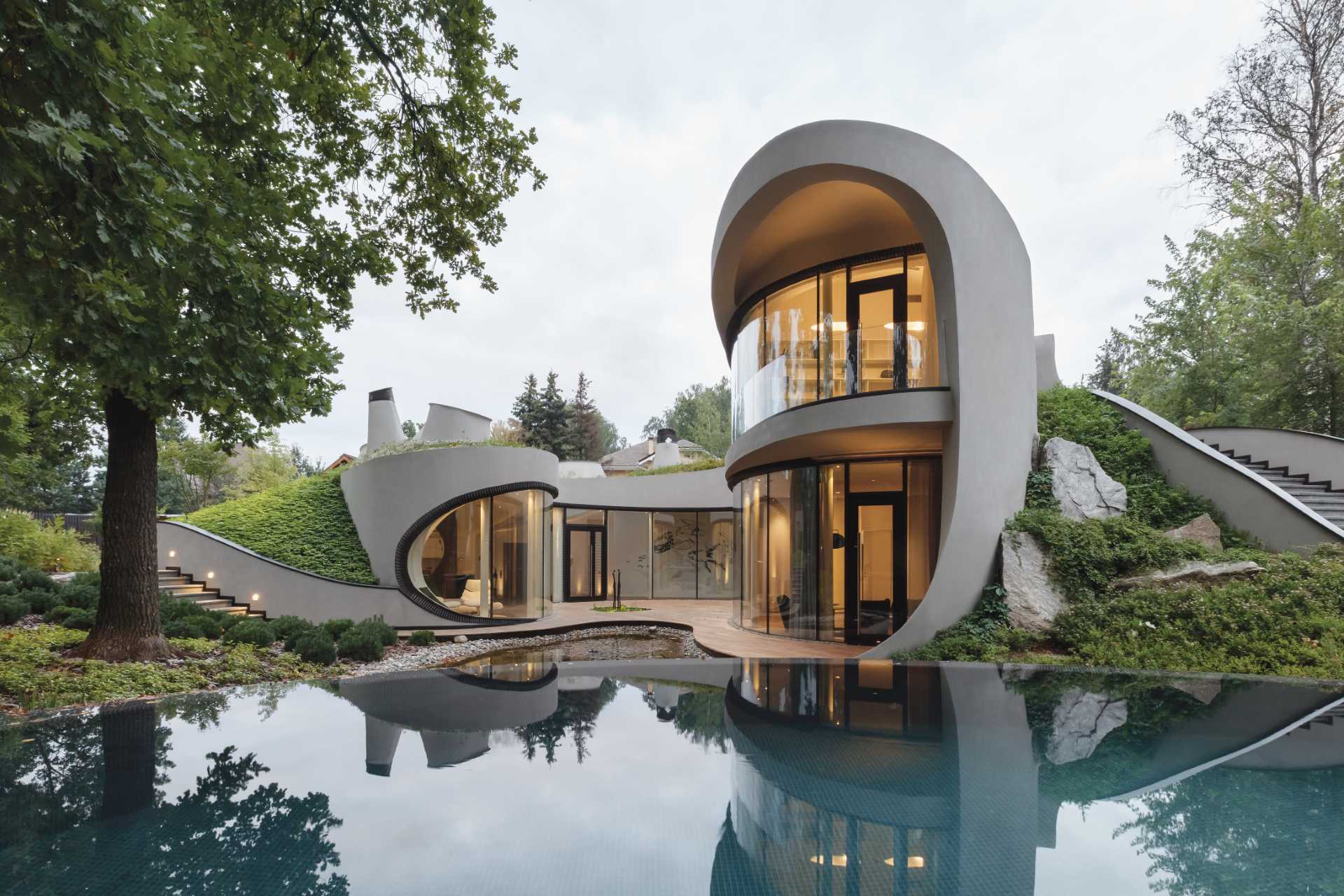 A modern sculptural home with curves that's been built into an artificially created landscape.