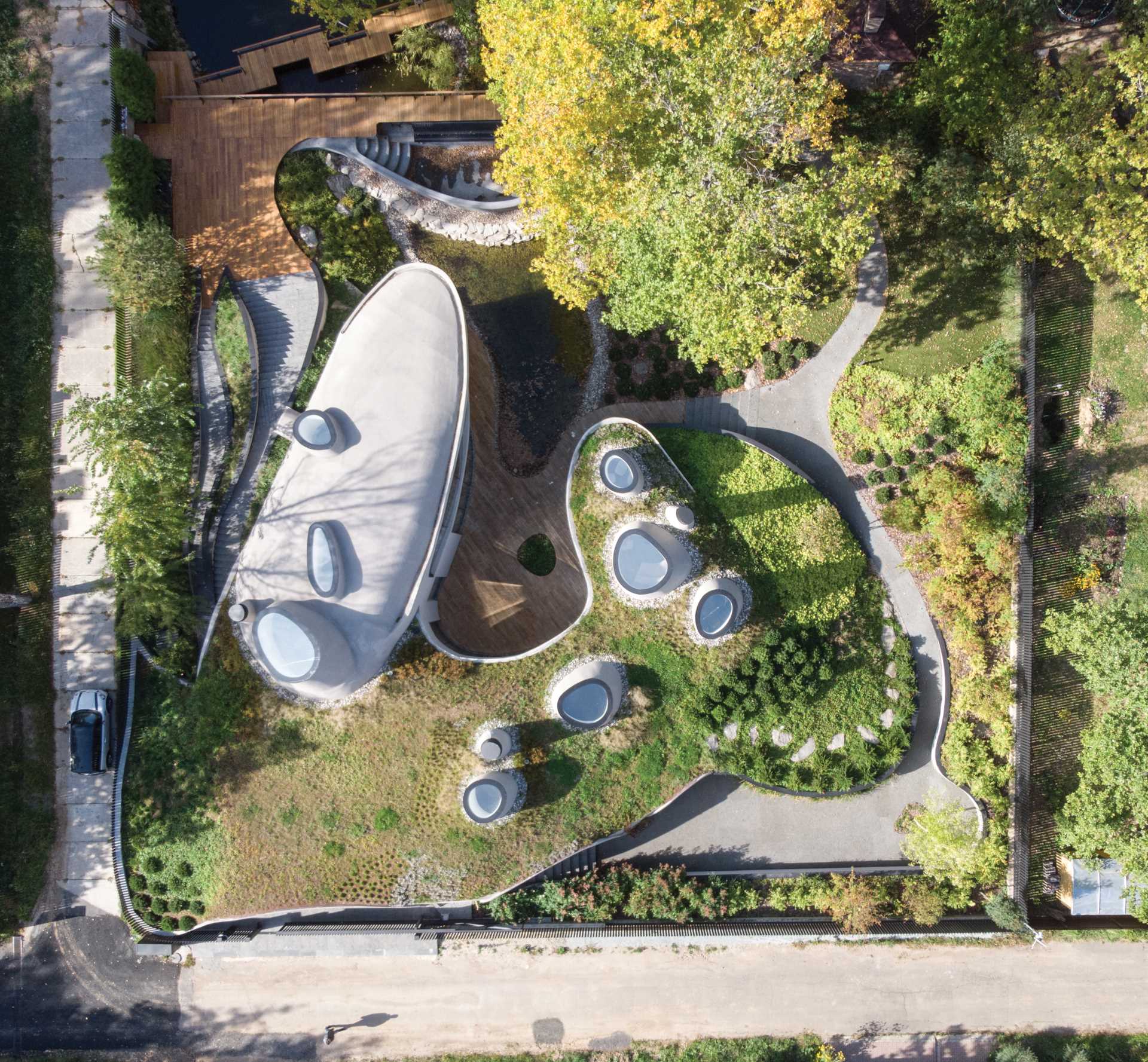 A modern sculptural home with curves that's been built into an artificially created landscape.