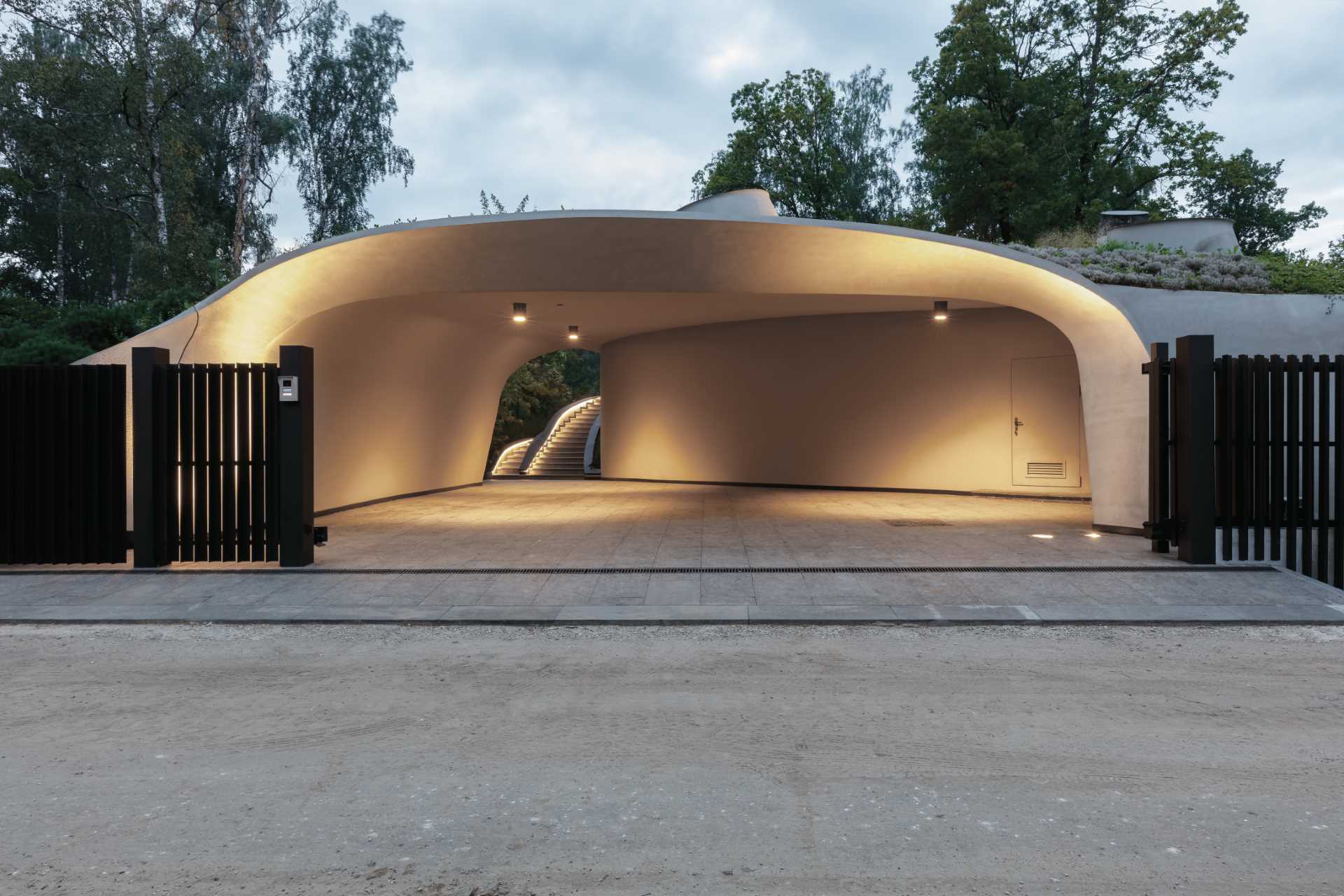 A modern sculptural home with curves that's been built into an artificially created landscape.