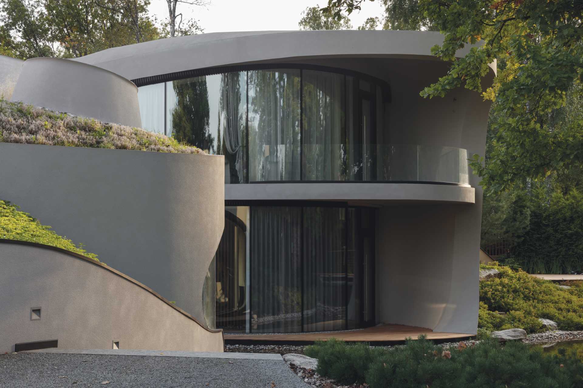 A modern sculptural home with curves that's been built into an artificially created landscape.