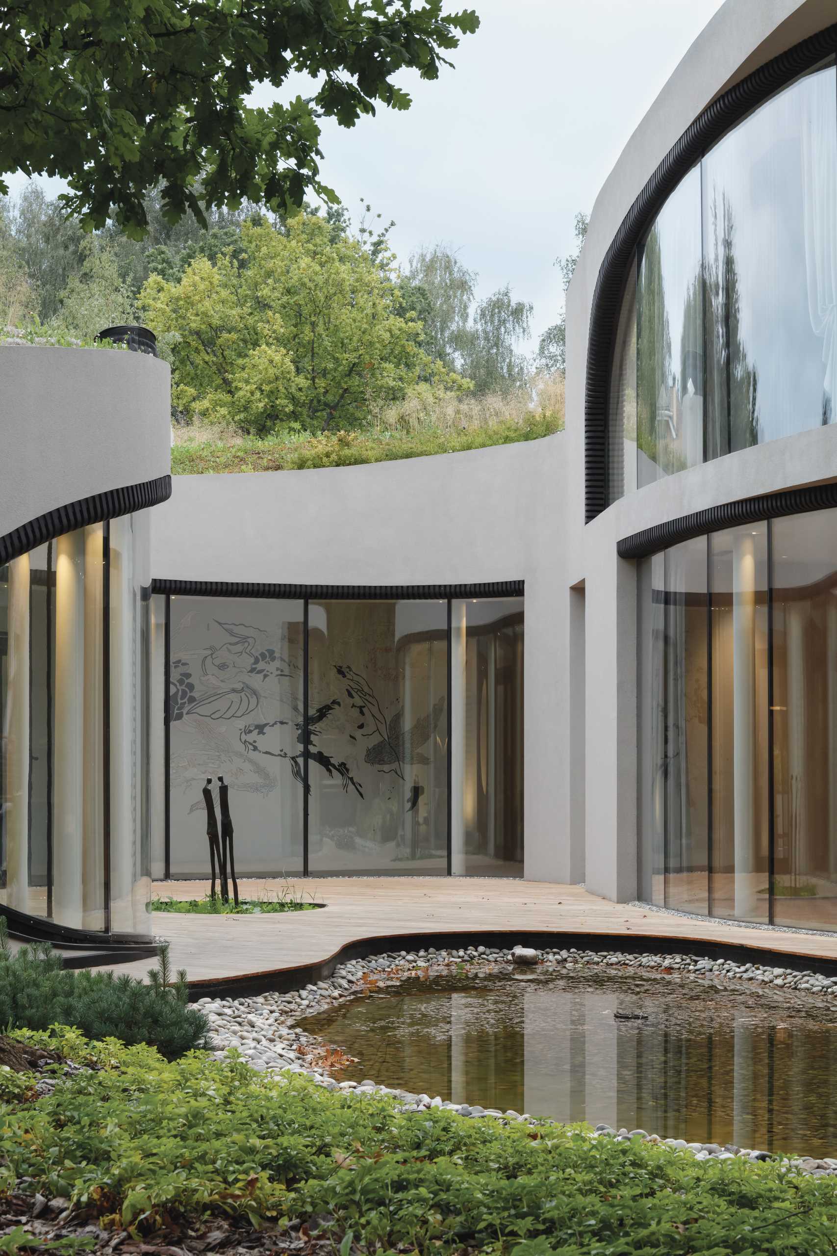 A modern sculptural home with curves that's been built into an artificially created landscape.