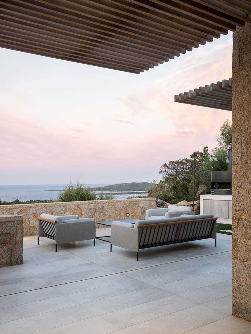 The outdoor spaces of this home include shade canopies made from Iroko wooden slats and powder-coated metal structure, while the terraced garden features an infinity pool.