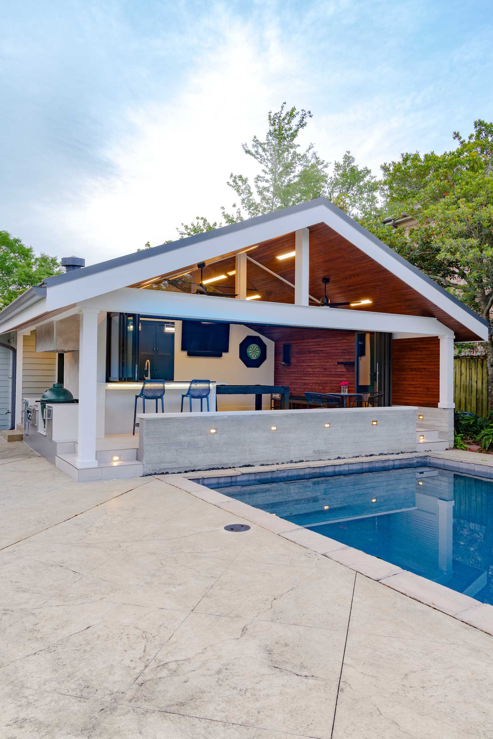 A garage was transformed into a modern pool house with a bar and covered seating.