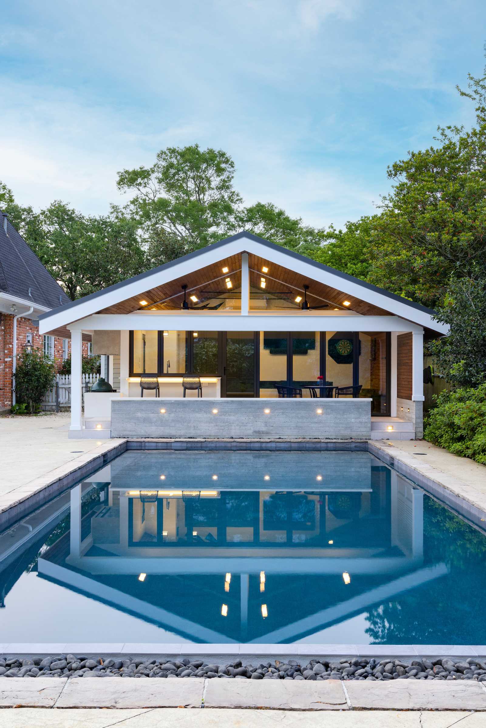 A garage was transformed into a modern pool house with a bar and covered seating.