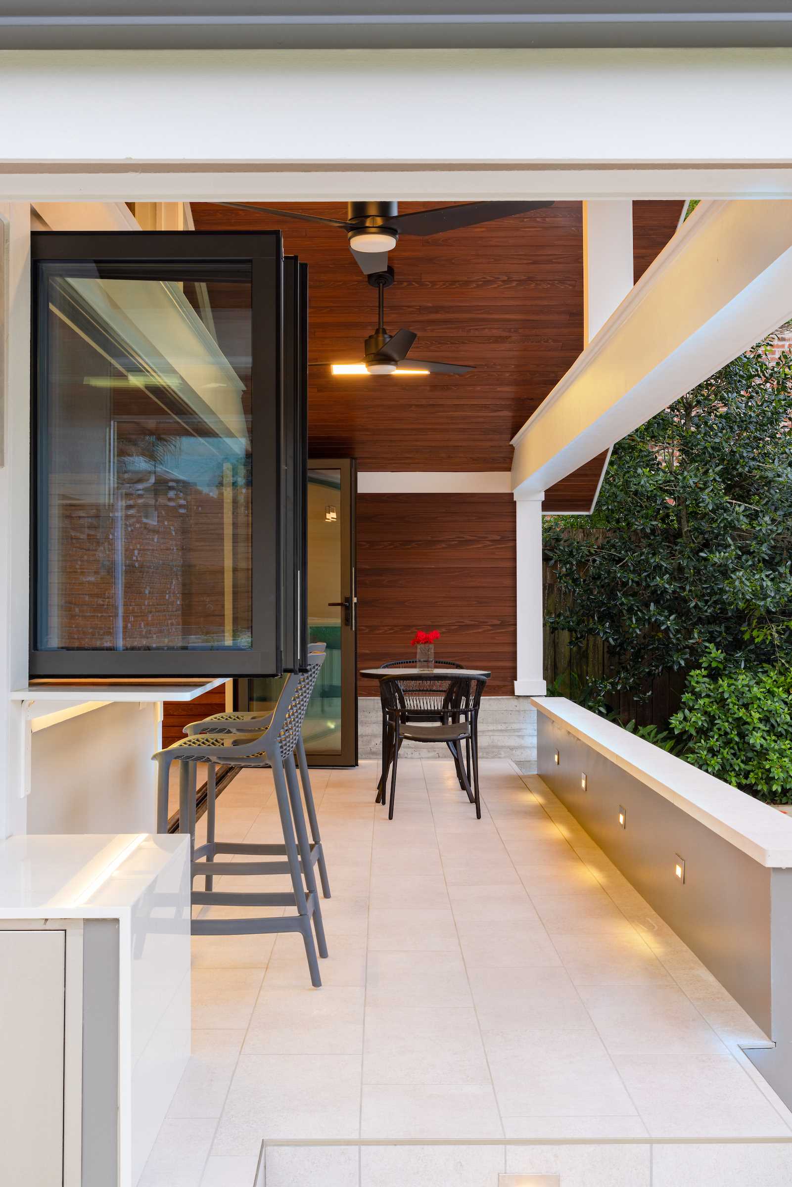 A garage was transformed into a modern pool house with a bar and covered seating.