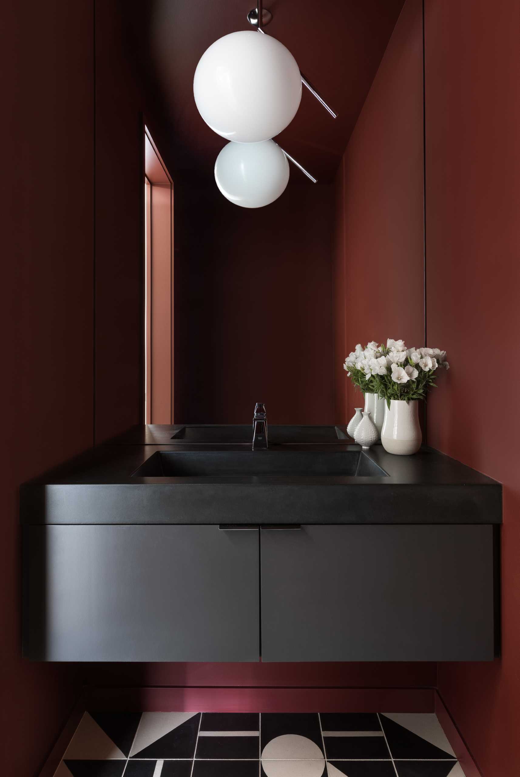 An unexpected splash of color can be seen in this powder room, which also features tiles with a geometric pattern.