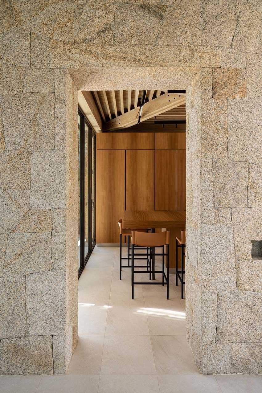 The kitchen is located off the dining room and through an opening in the stone wall. The warm wood cabinets complement the kitchen island, which has an overhang for seating.
