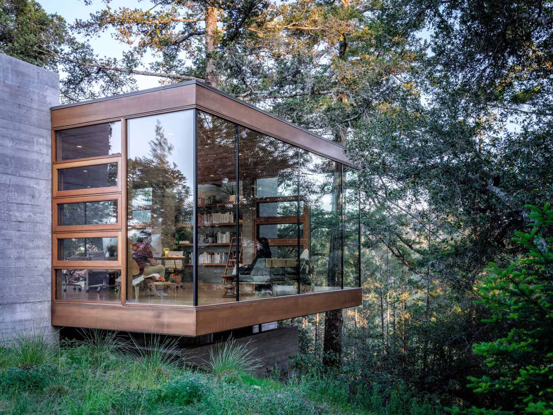 A wood-framed glass box is home to a backyard office.