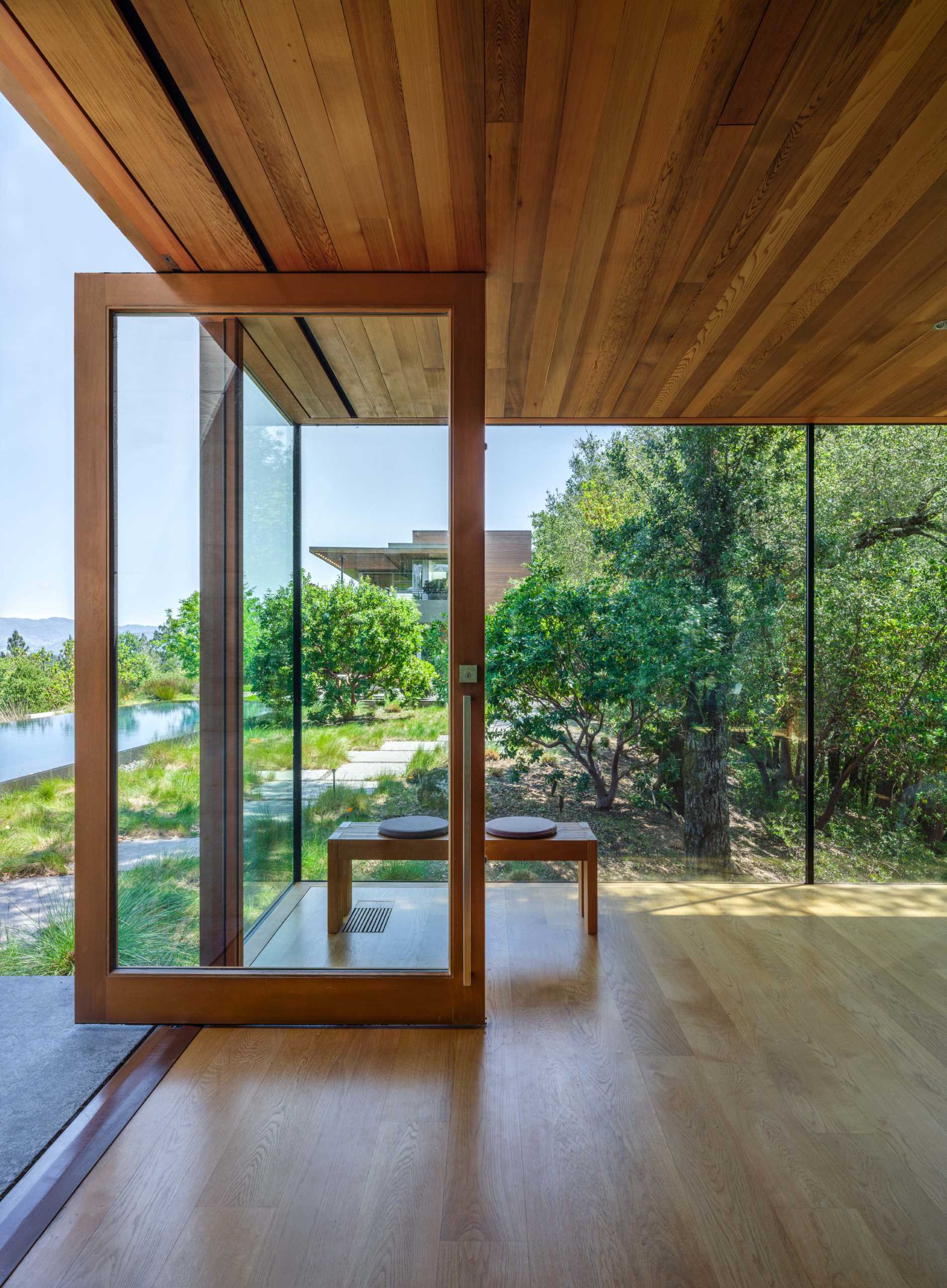 A wood-framed glass box is home to a backyard office.