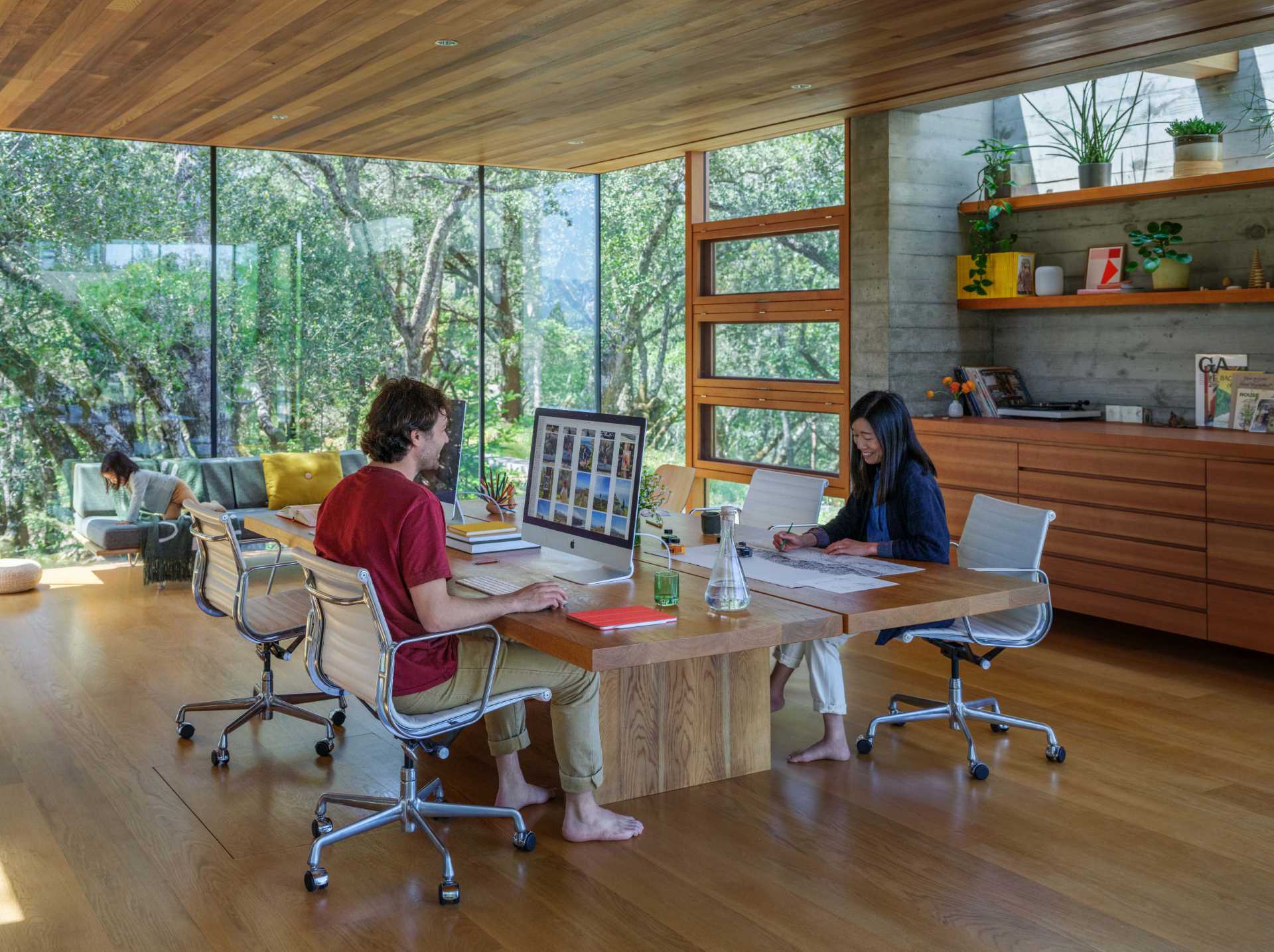 A wood-framed glass box is home to a backyard office.