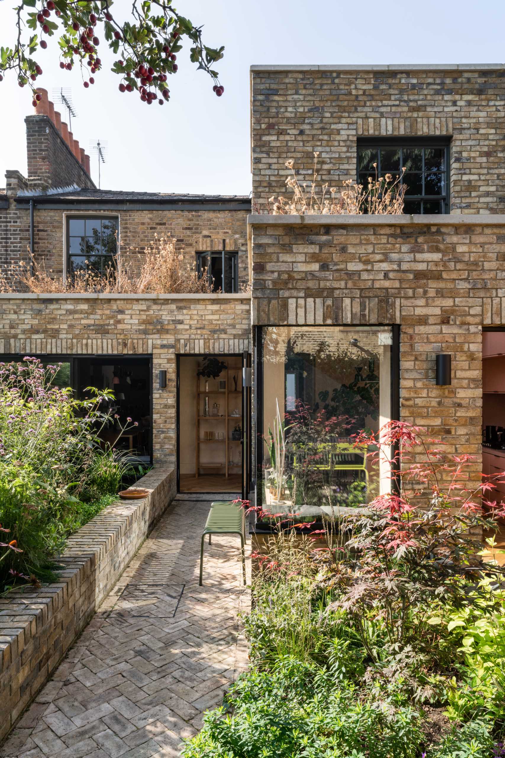 A brick home extension with a blush pink kitchen and window seats.