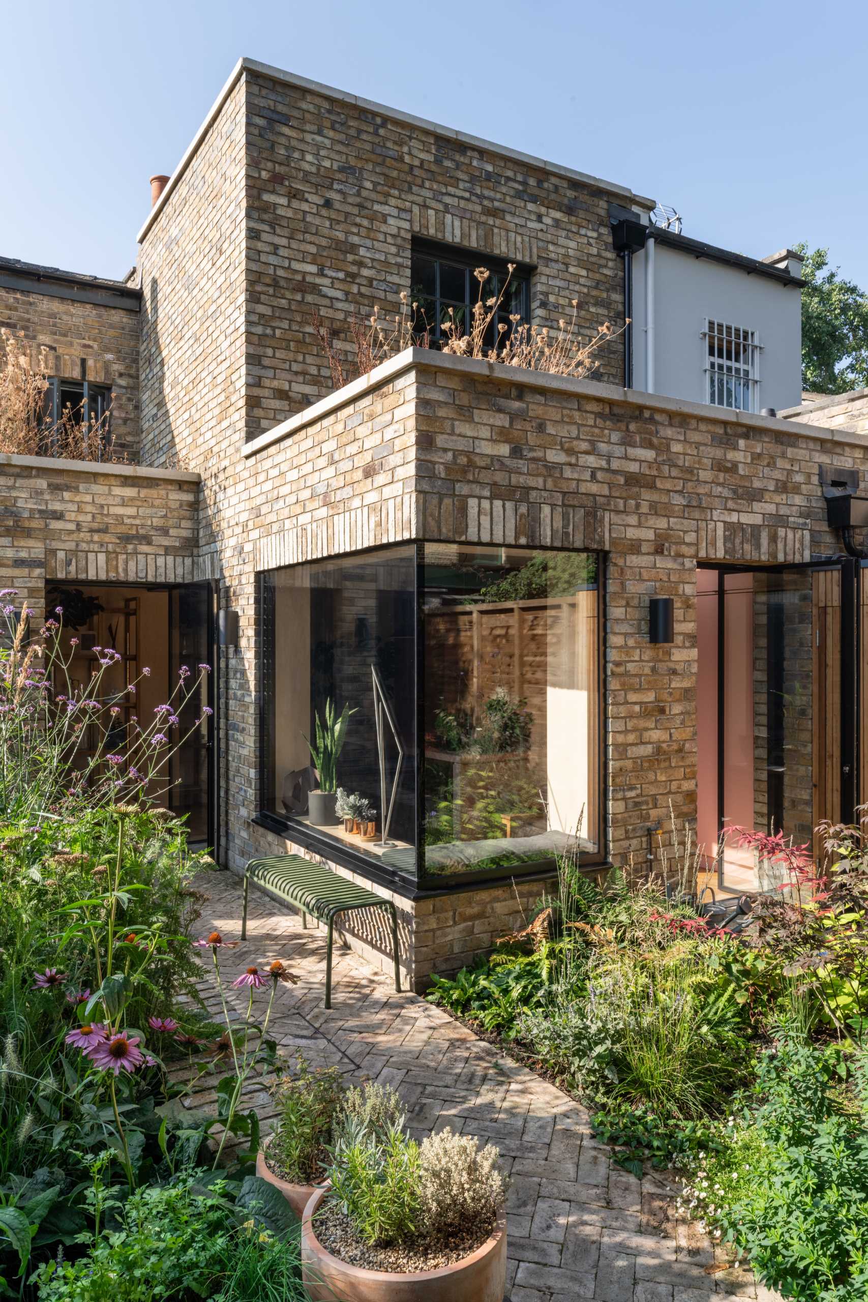 A brick home extension with a blush pink kitchen and window seats.