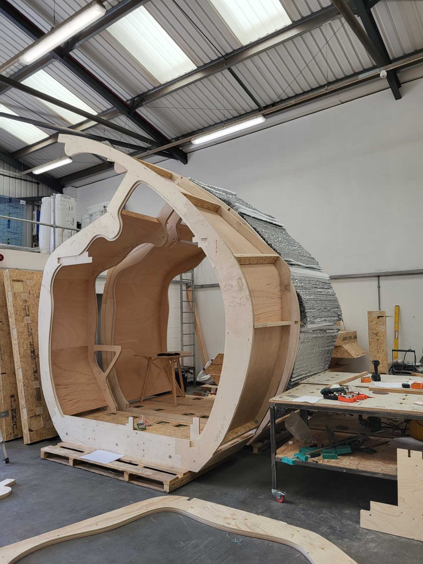 A small organically shaped cabin clad in wood shingles.