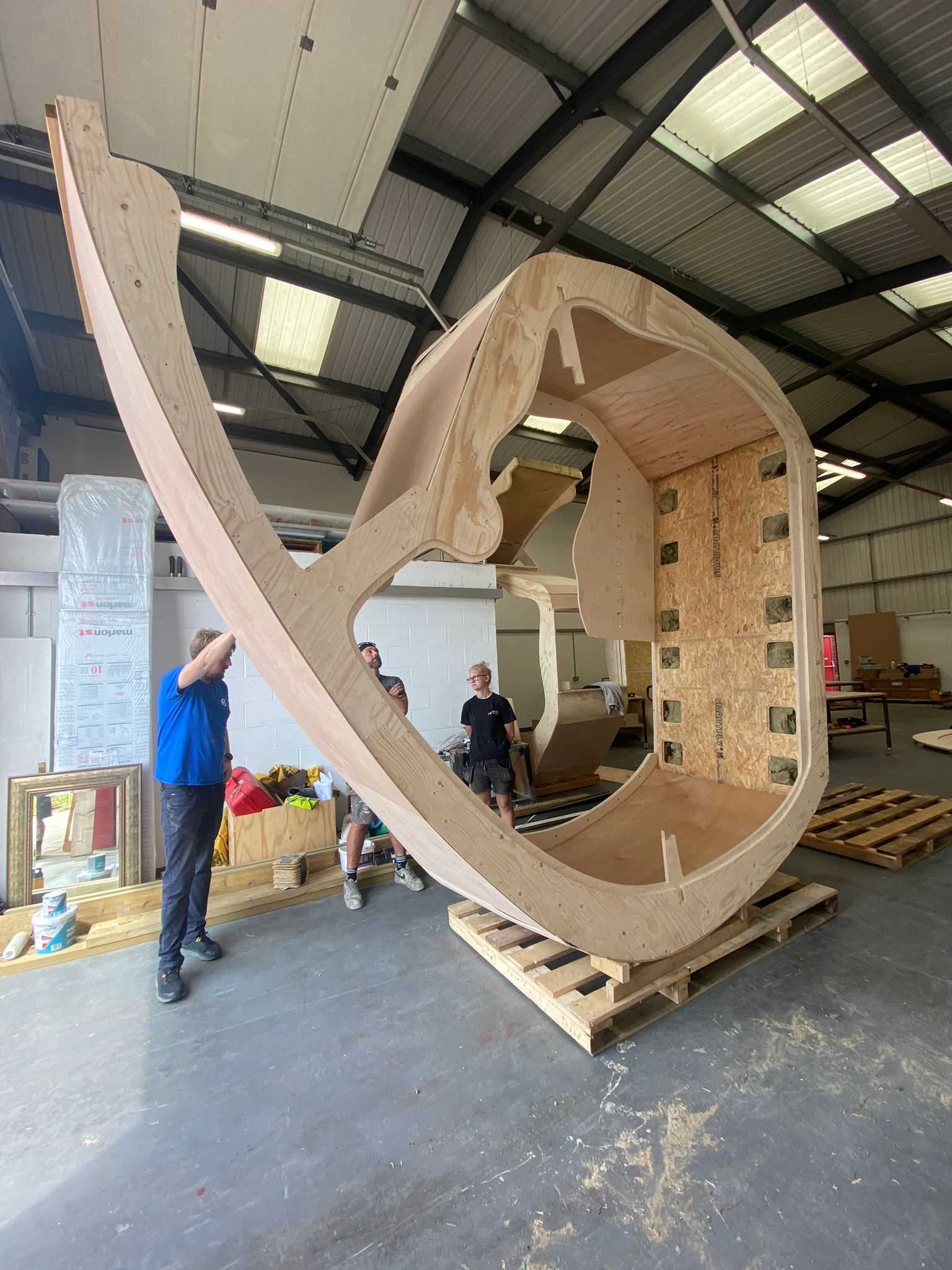 A small organically shaped cabin clad in wood shingles.