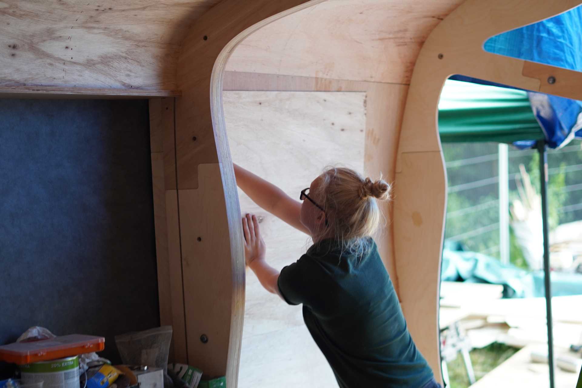 A small organically shaped cabin clad in wood shingles.