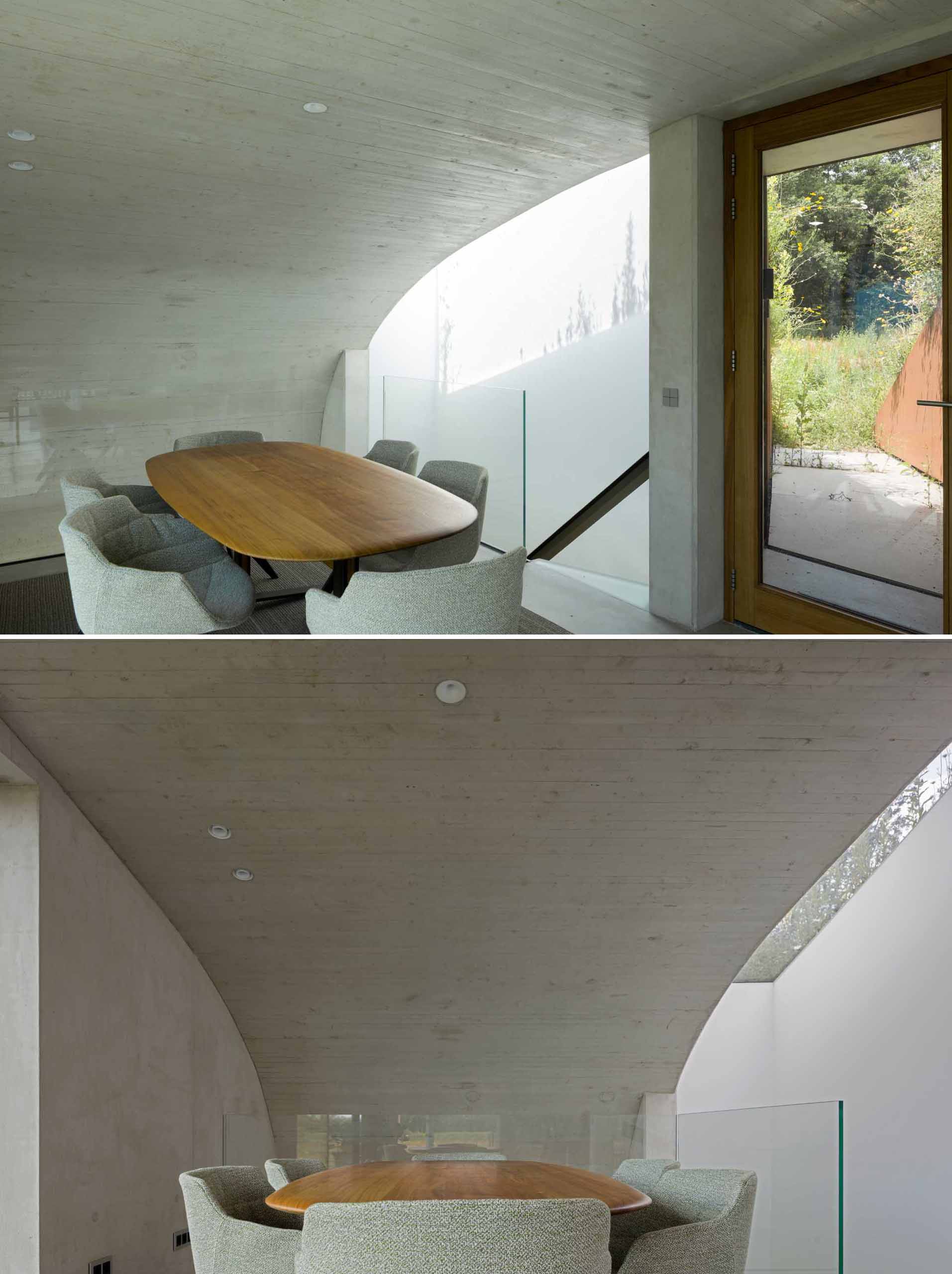 Stepping inside the home, the curved ceiling in the dining area reflects the shape of the plant-covered hill on the outside.