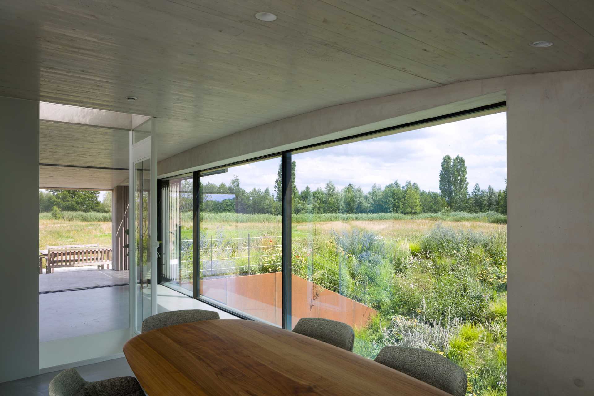 Stepping inside the home, the curved ceiling in the dining area reflects the shape of the plant-covered hill on the outside.