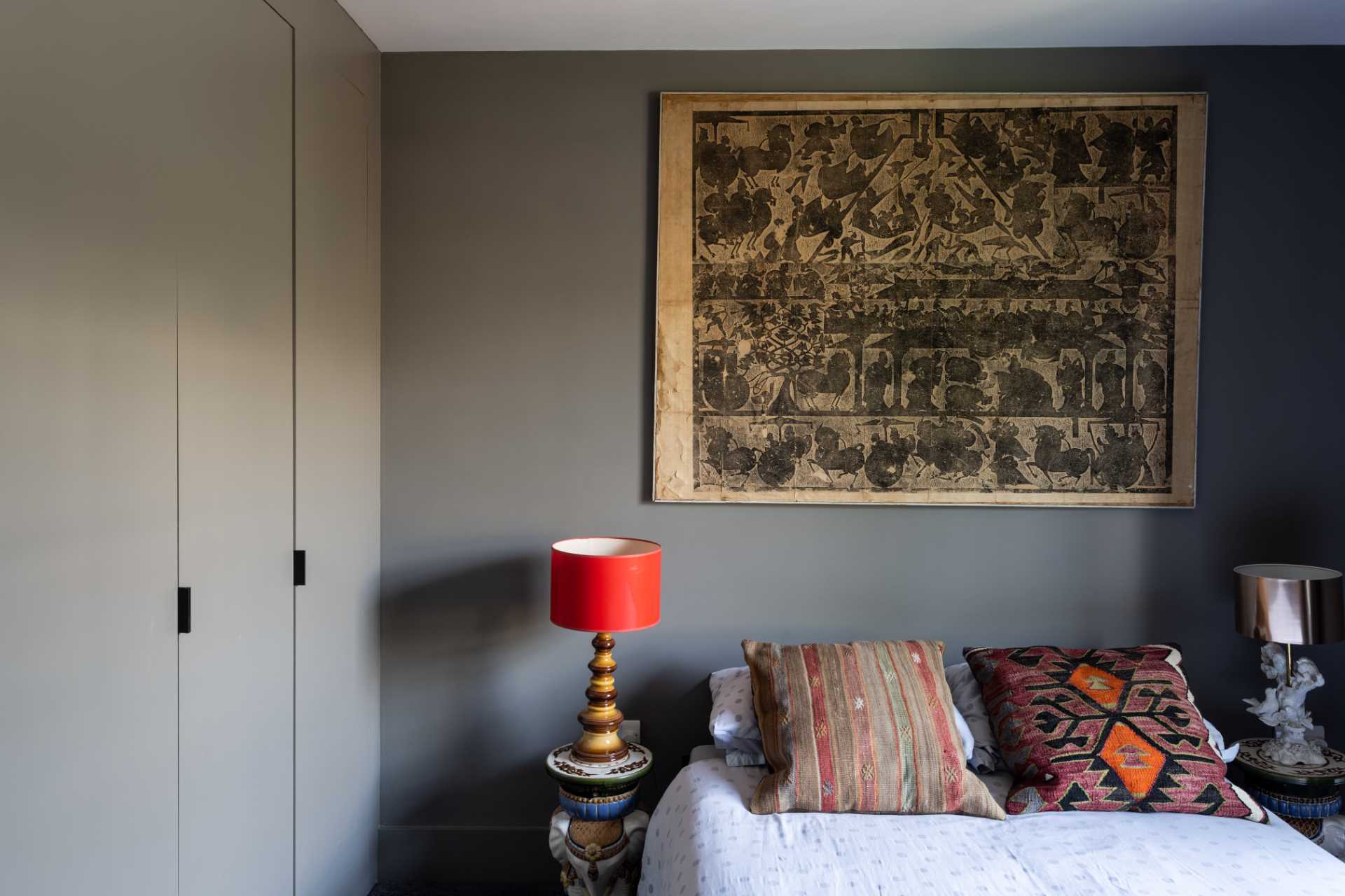 In a guest bedroom, dark walls allow the colorful accents to stand out.