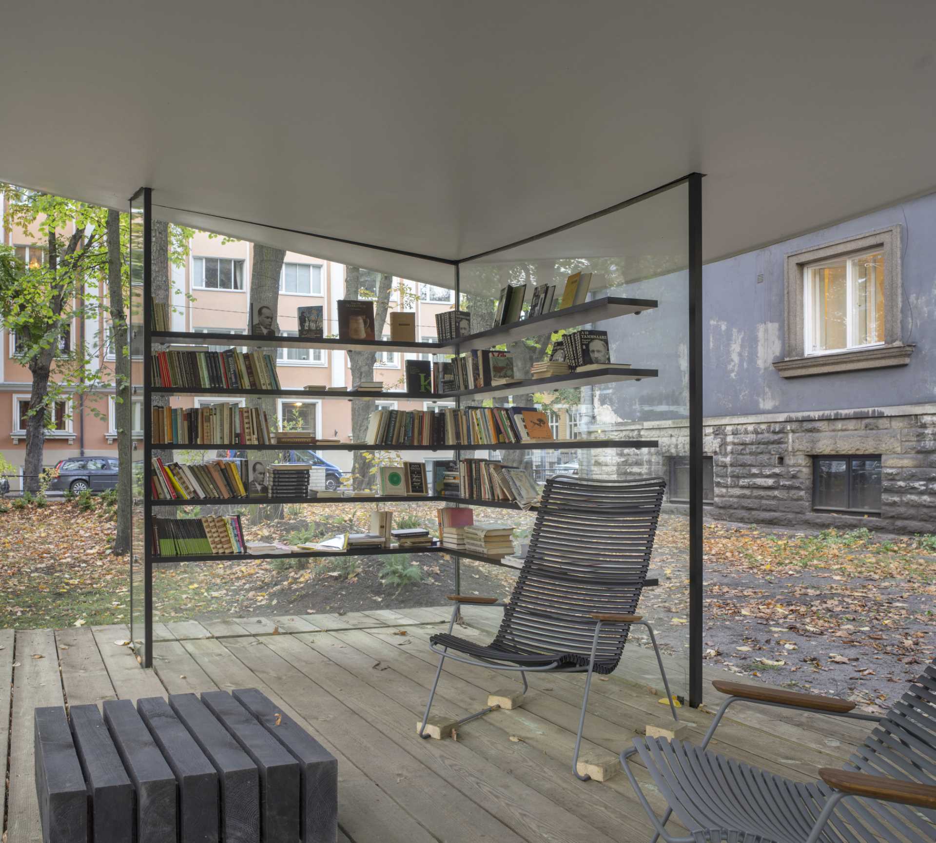 A small public library with glass walls and a white roof that's inspired by a sheet of paper.