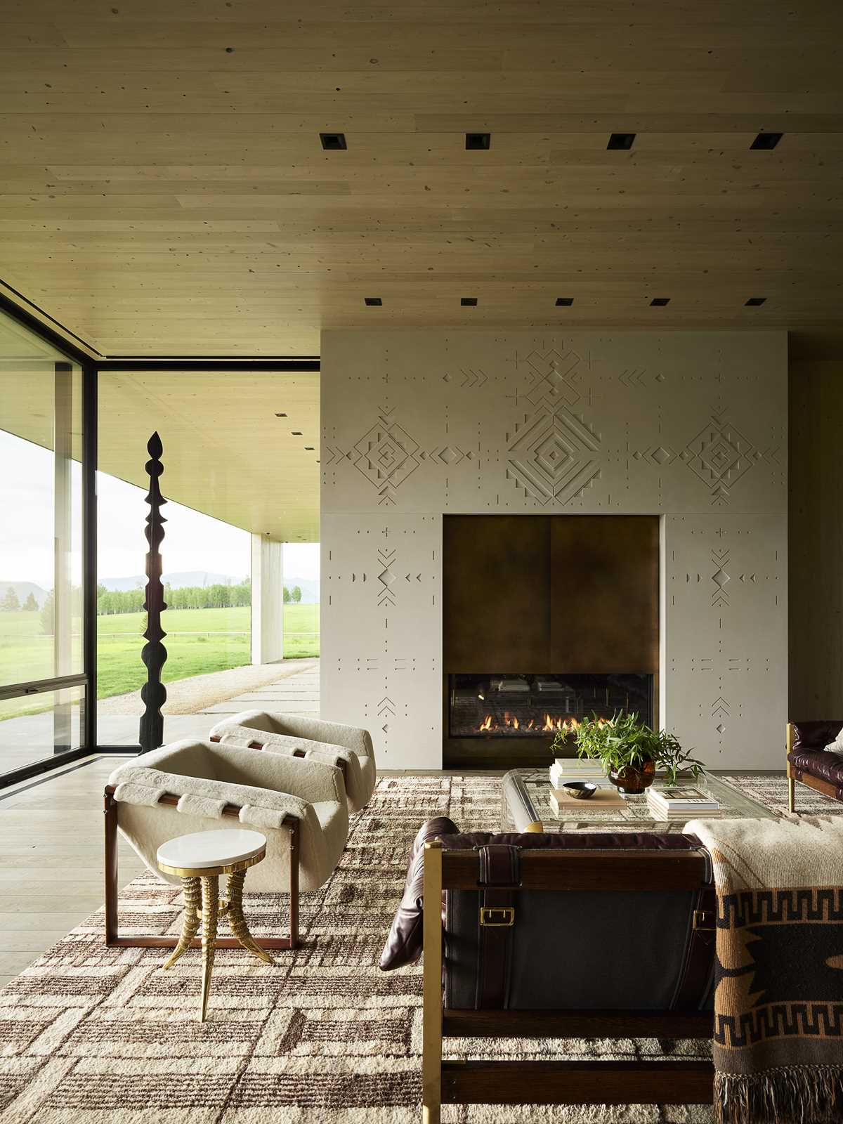 In the living room, custom-designed, tattoo-inspired bas relief concrete surrounds the fireplace.