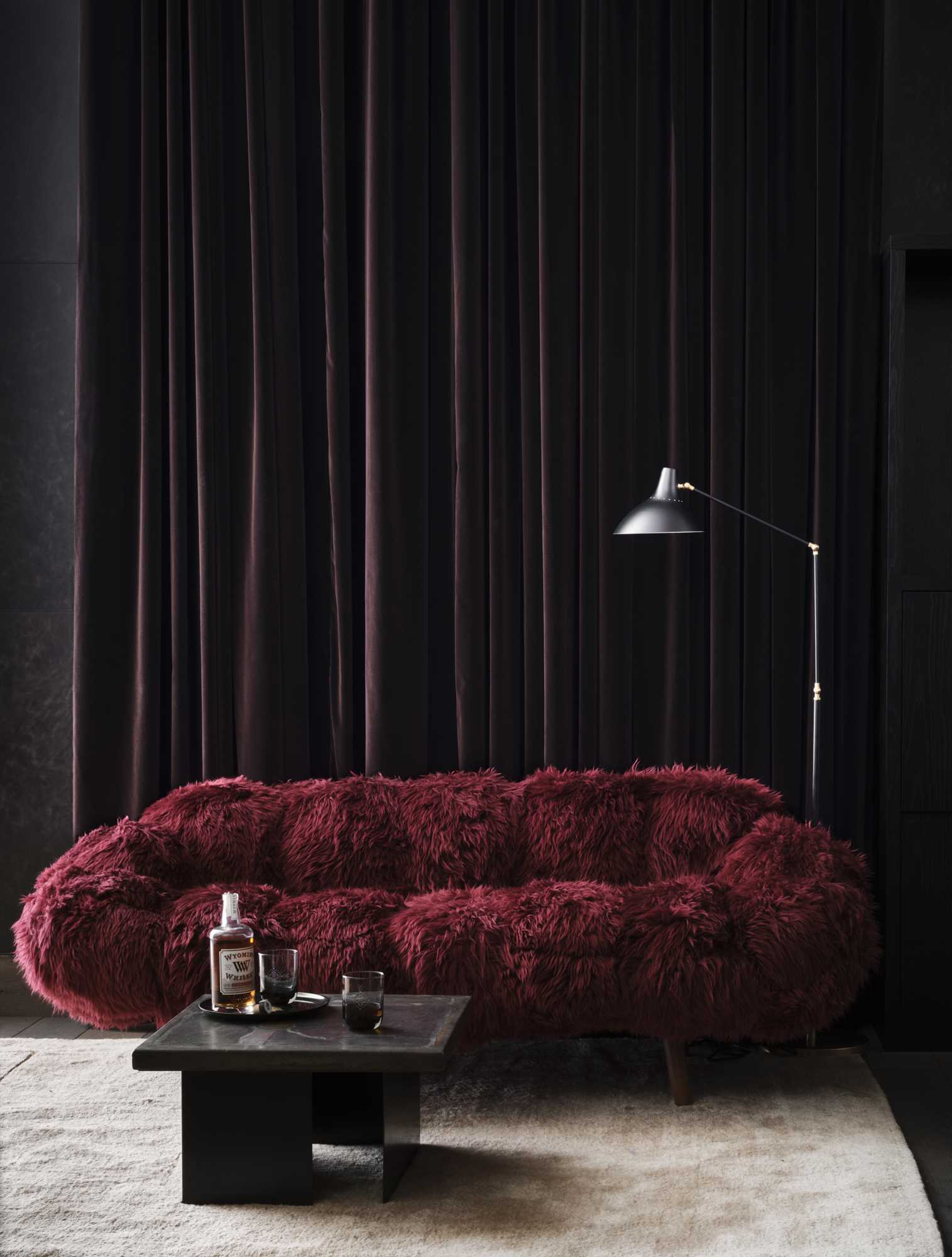 A luxurious red couch with a dark background.