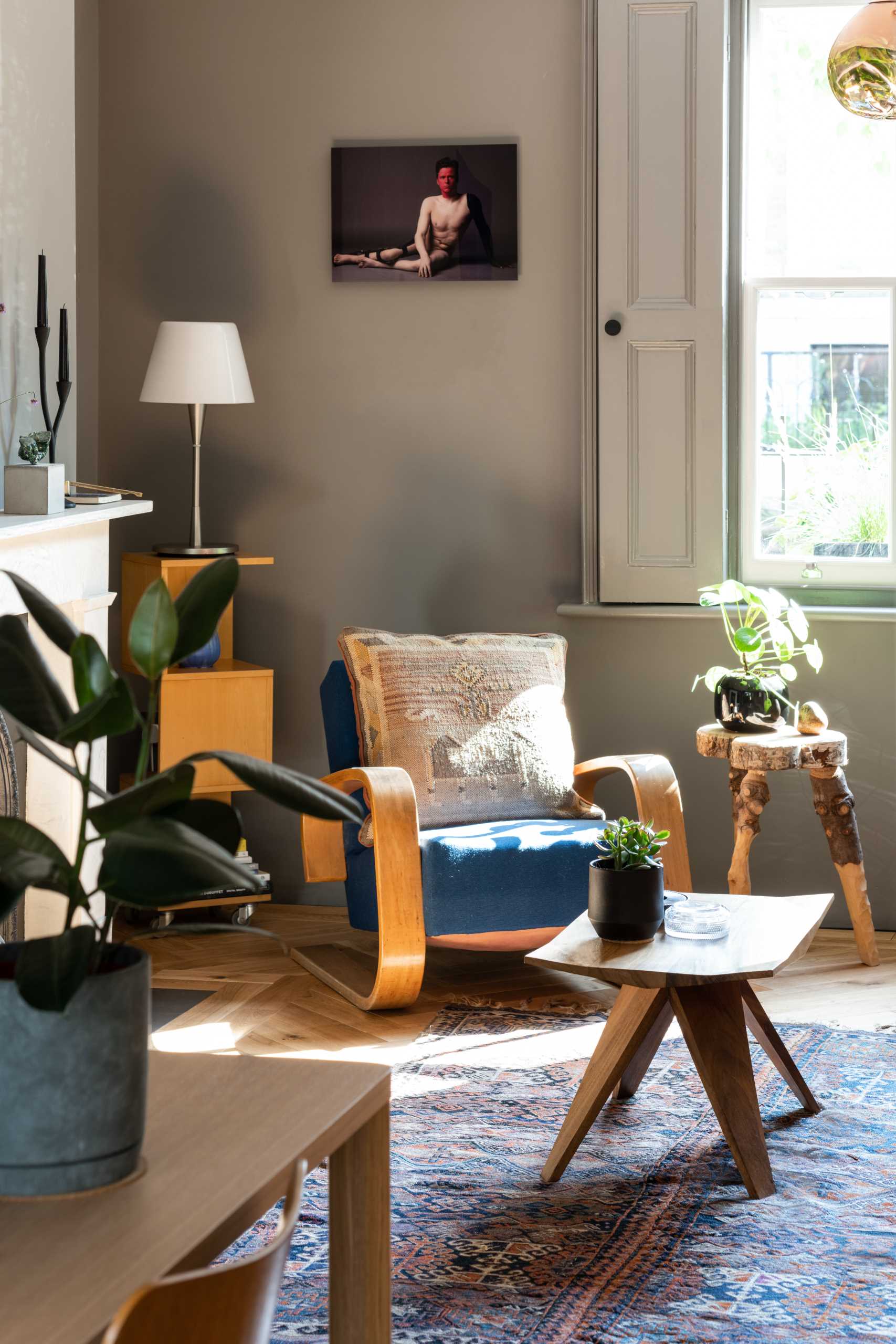 This living room, with views of the street, has wall-mounted bookshelves and dark walls.