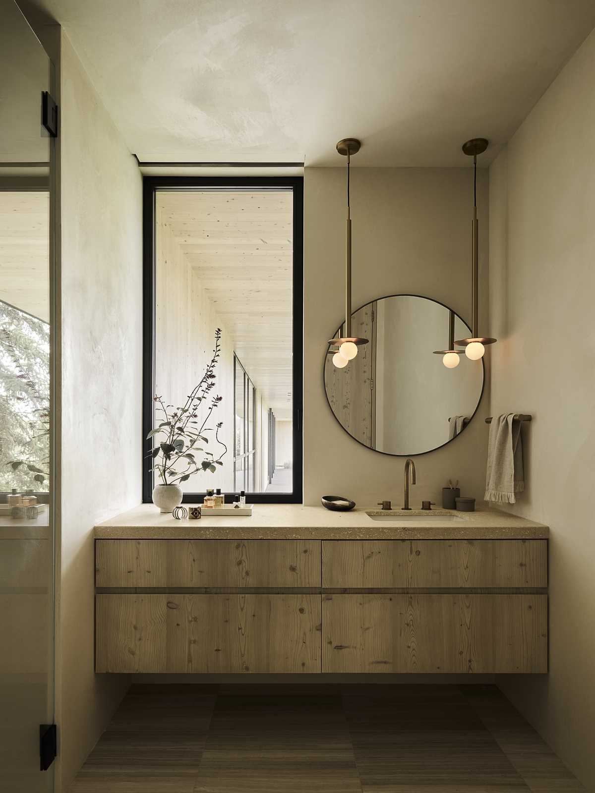 A modern bathroom with a round mirror.