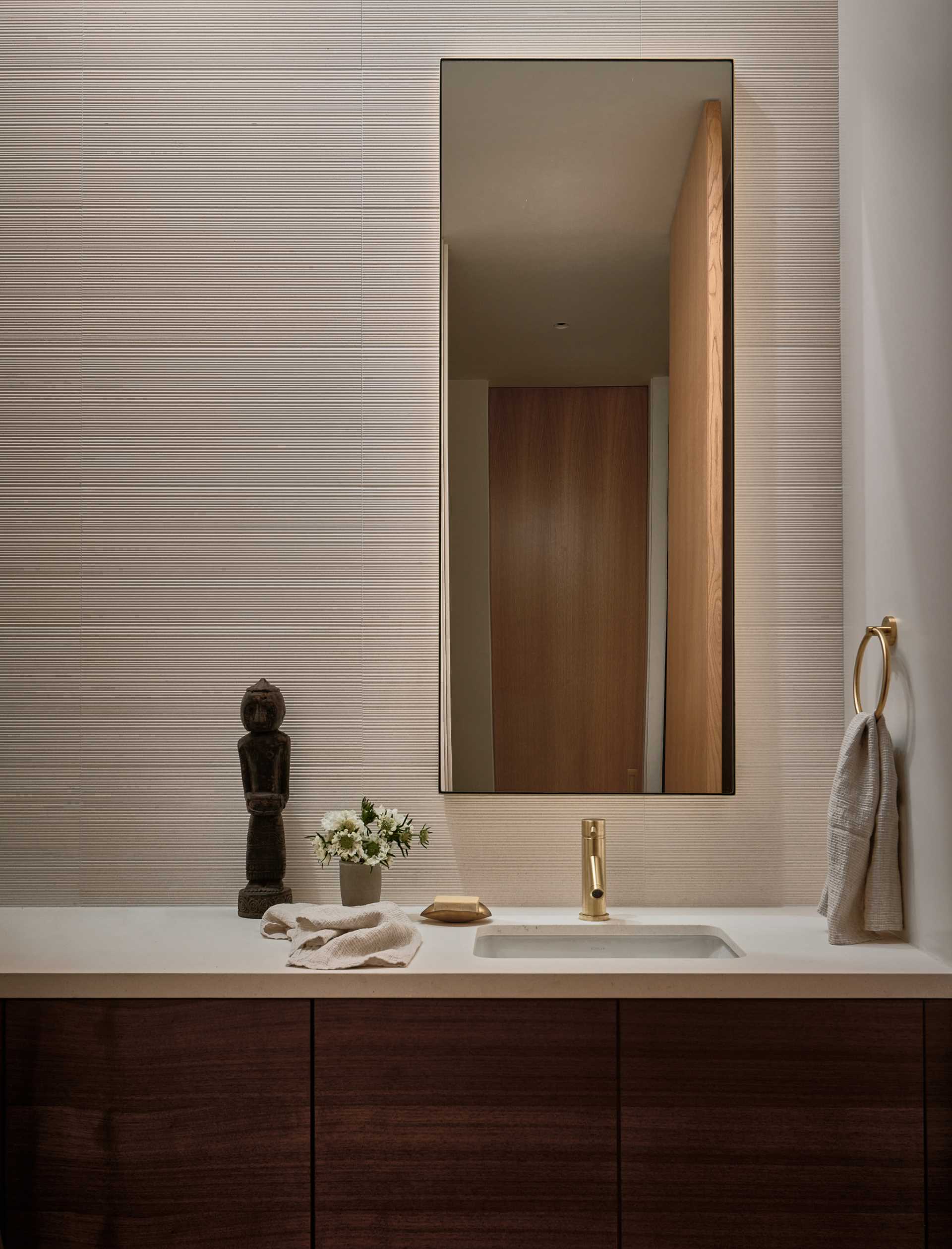 A tall mirror adds a sense of height to this bathroom.