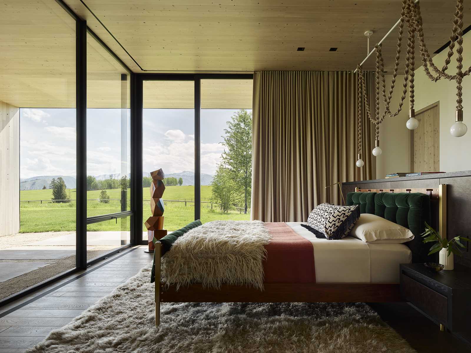 A modern bedroom with floor-to-ceiling windows and a wood ceiling.