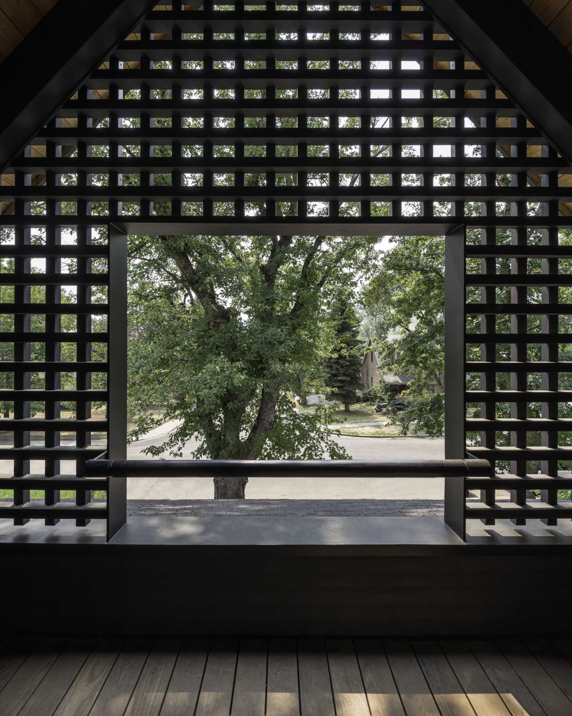 A modern home features a black lattice screen on its exterior.