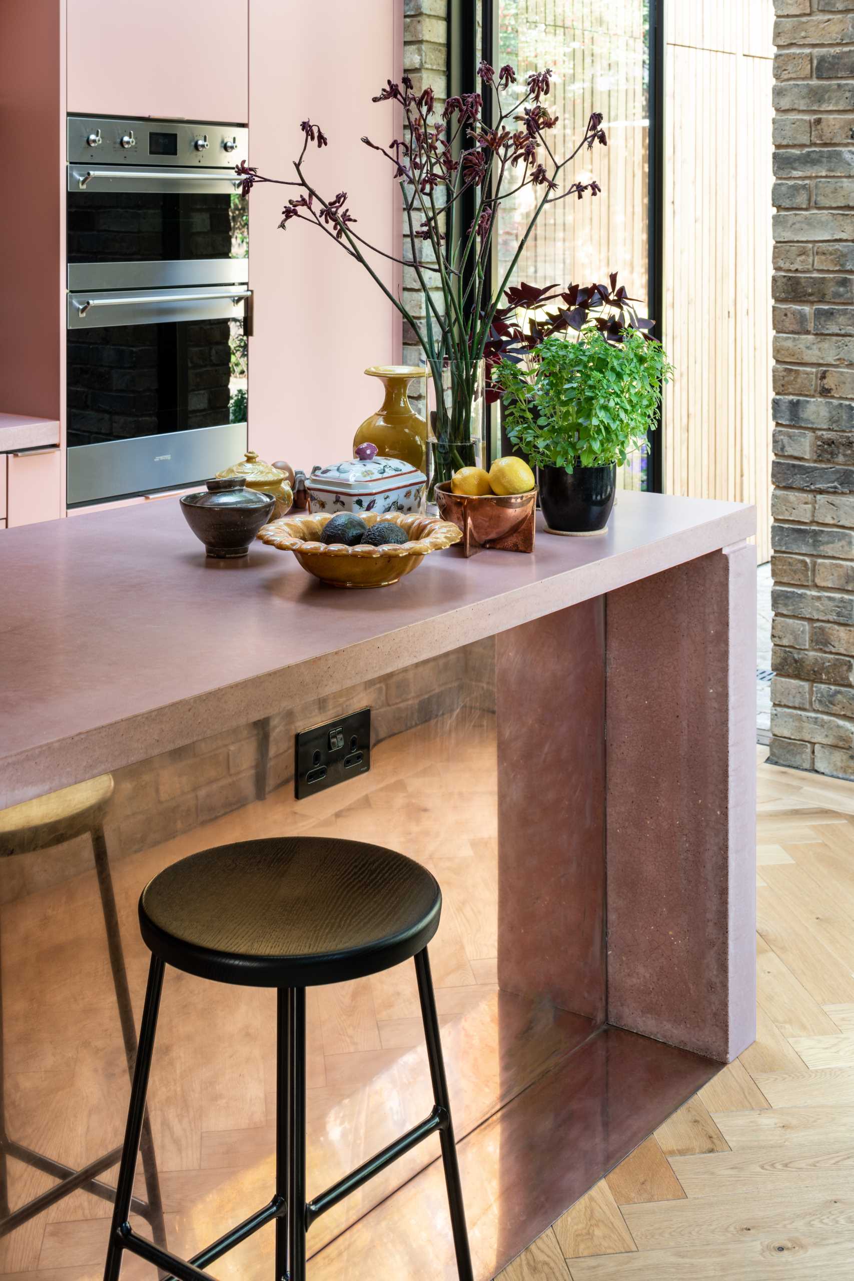 A brick home extension with a blush pink kitchen and window seats.