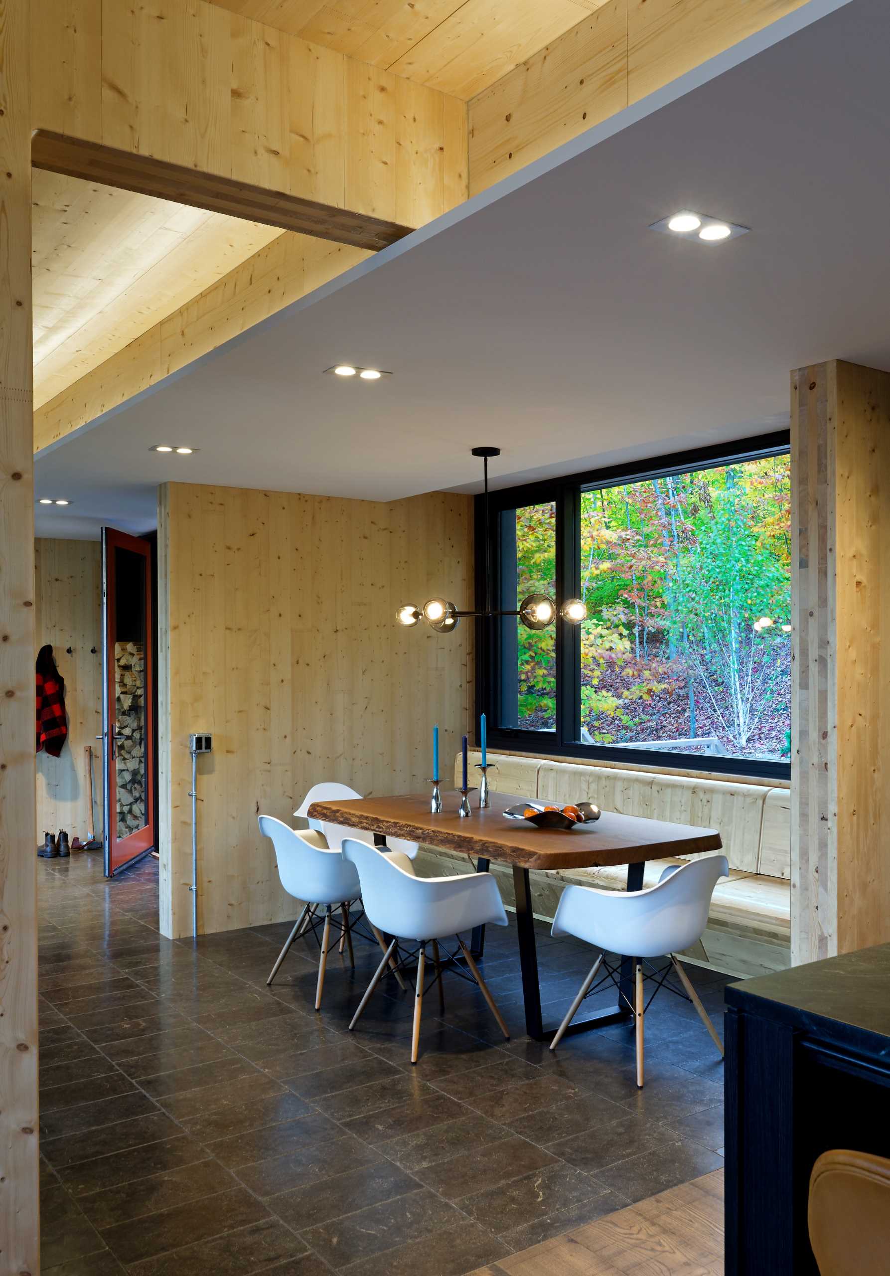 A contemporary dining area with a built-in banquette and large window.