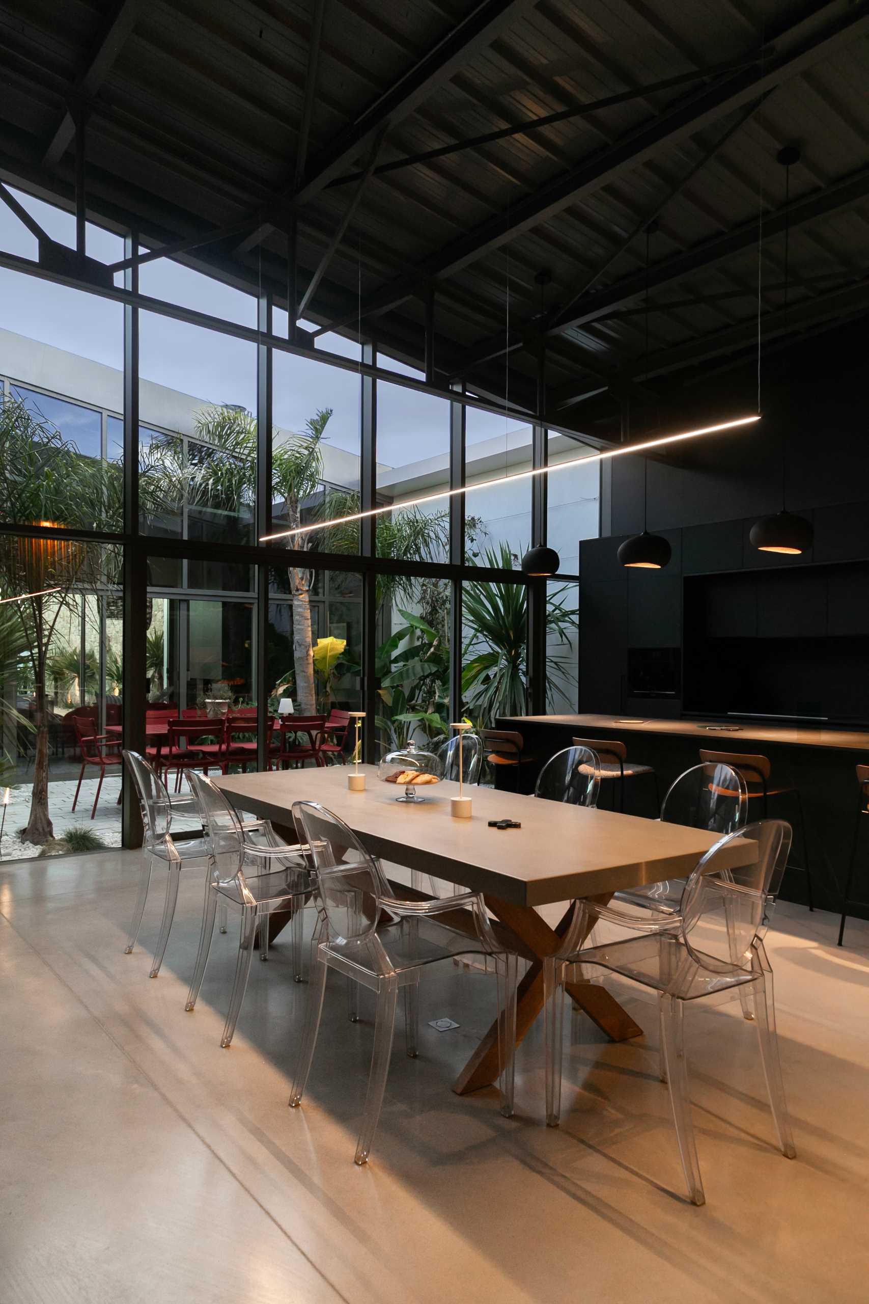 A warehouse conversion with a minimalist black kitchen and open plan dining area.