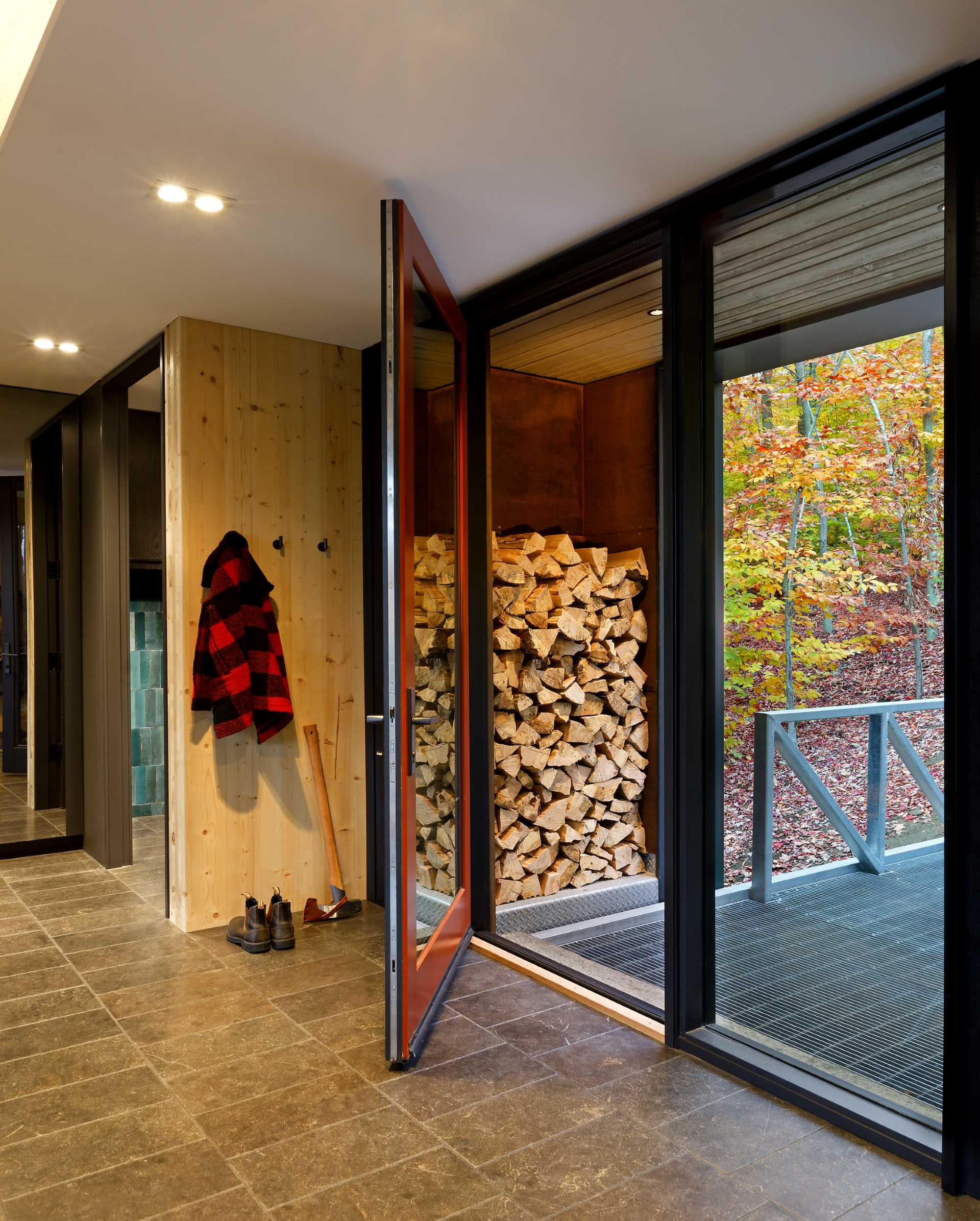 The entryway of this lakehouse includes outdoor storage for firewood.