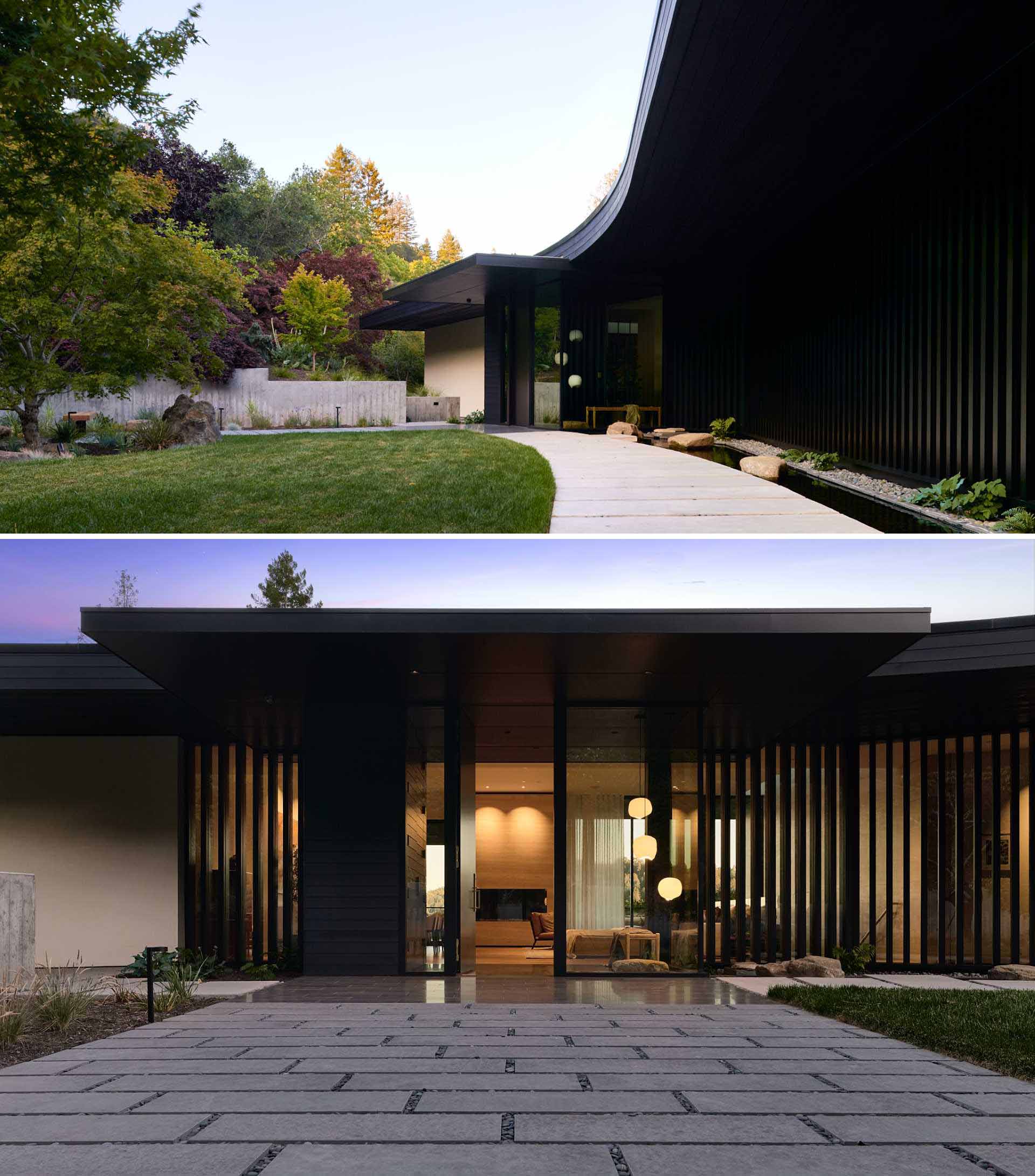 At the front of the house, a path leads to the front door that opens to an entryway with floor-to-ceiling windows.